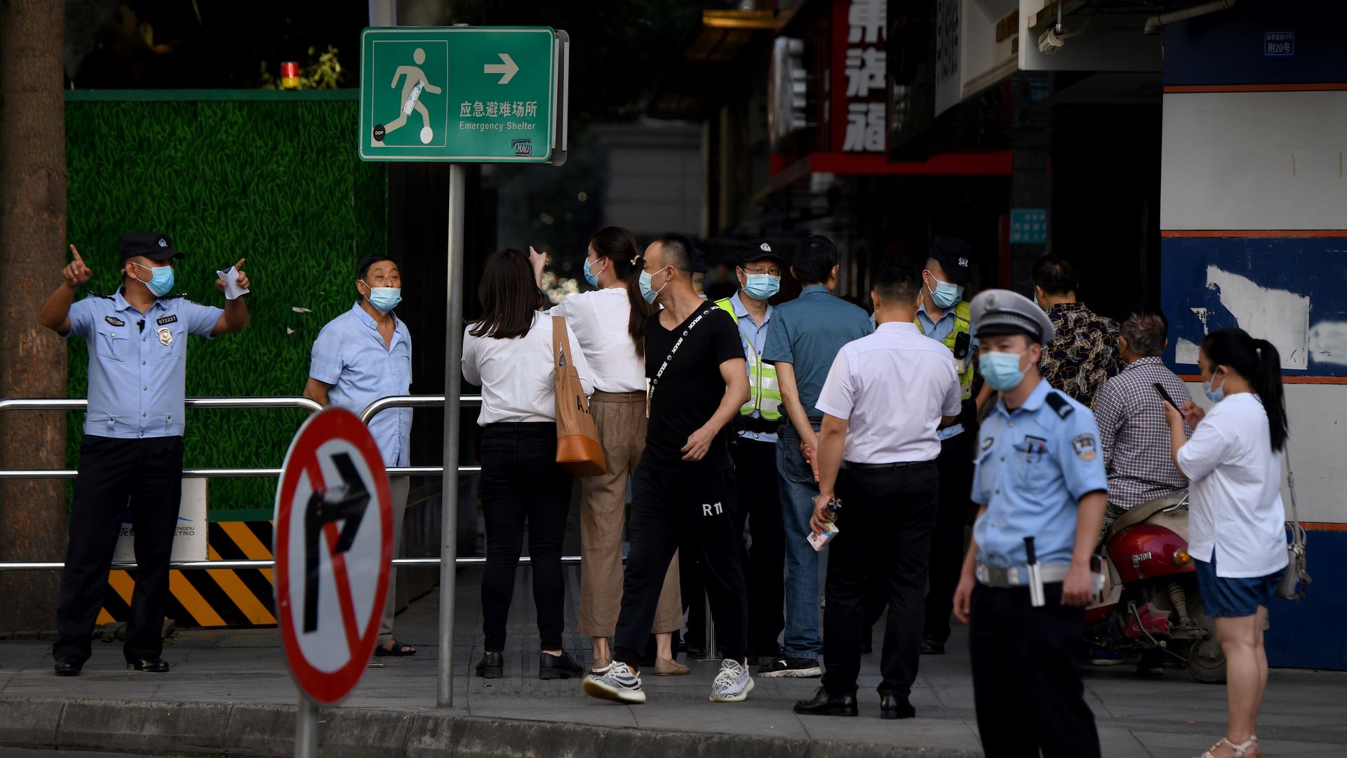 People attempt to enter a road leading to the US Consulate blocked by policemen in Chengdu, southwestern China's Sichuan province on July 27