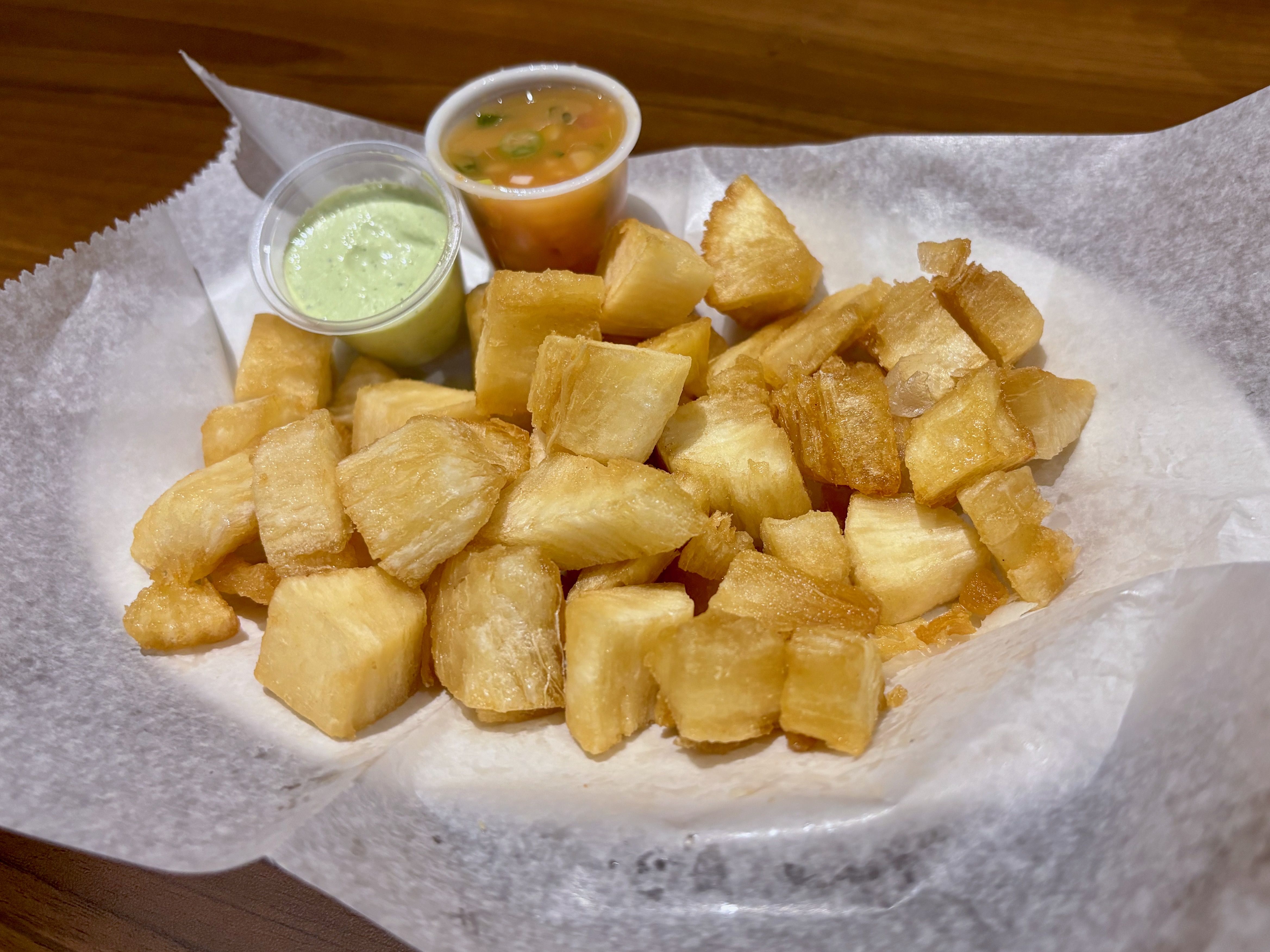 A close-up of the fried yuca with two different dipping sauces