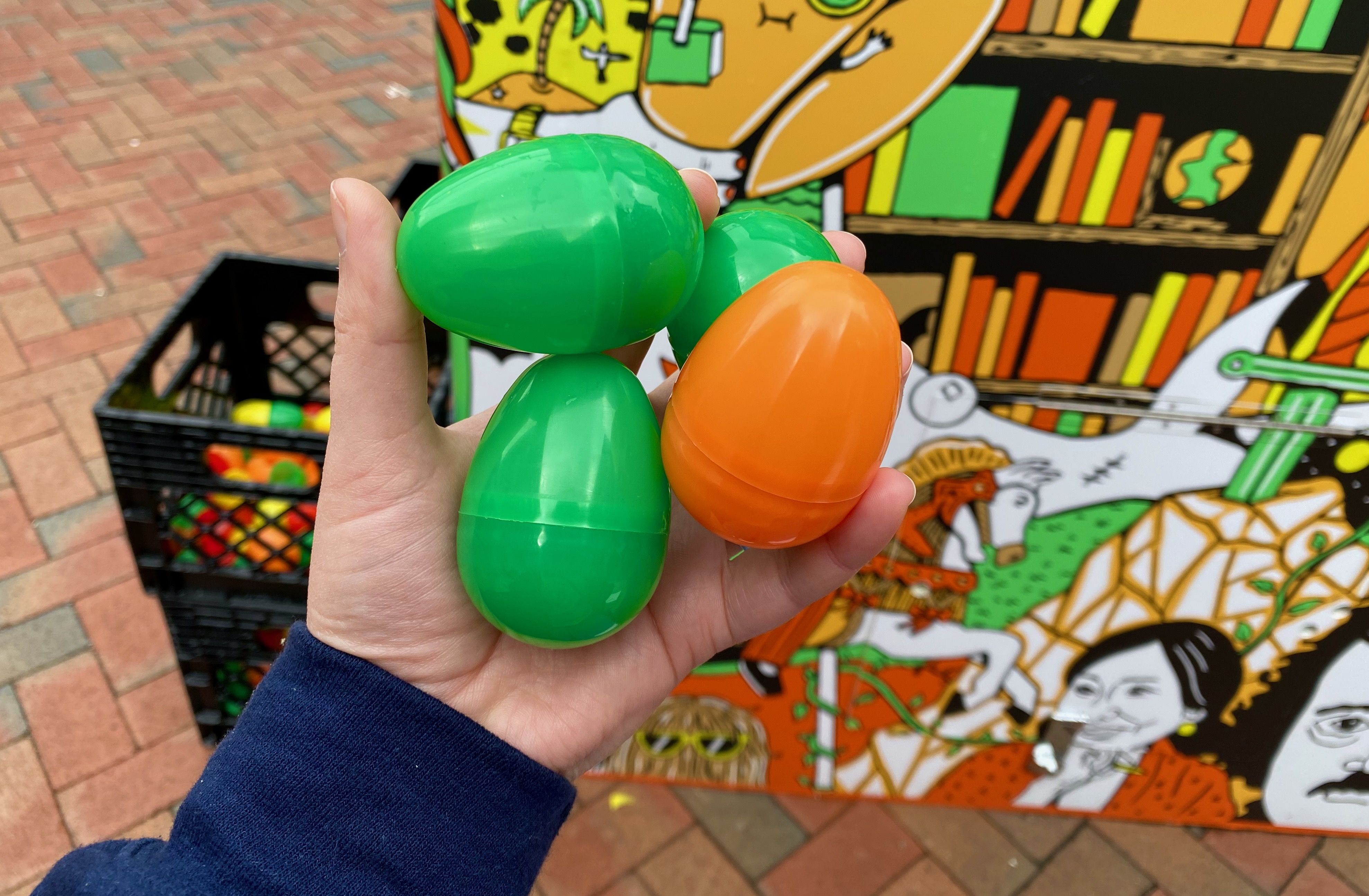 Alissa holds four plastic eggs, three green and one orange