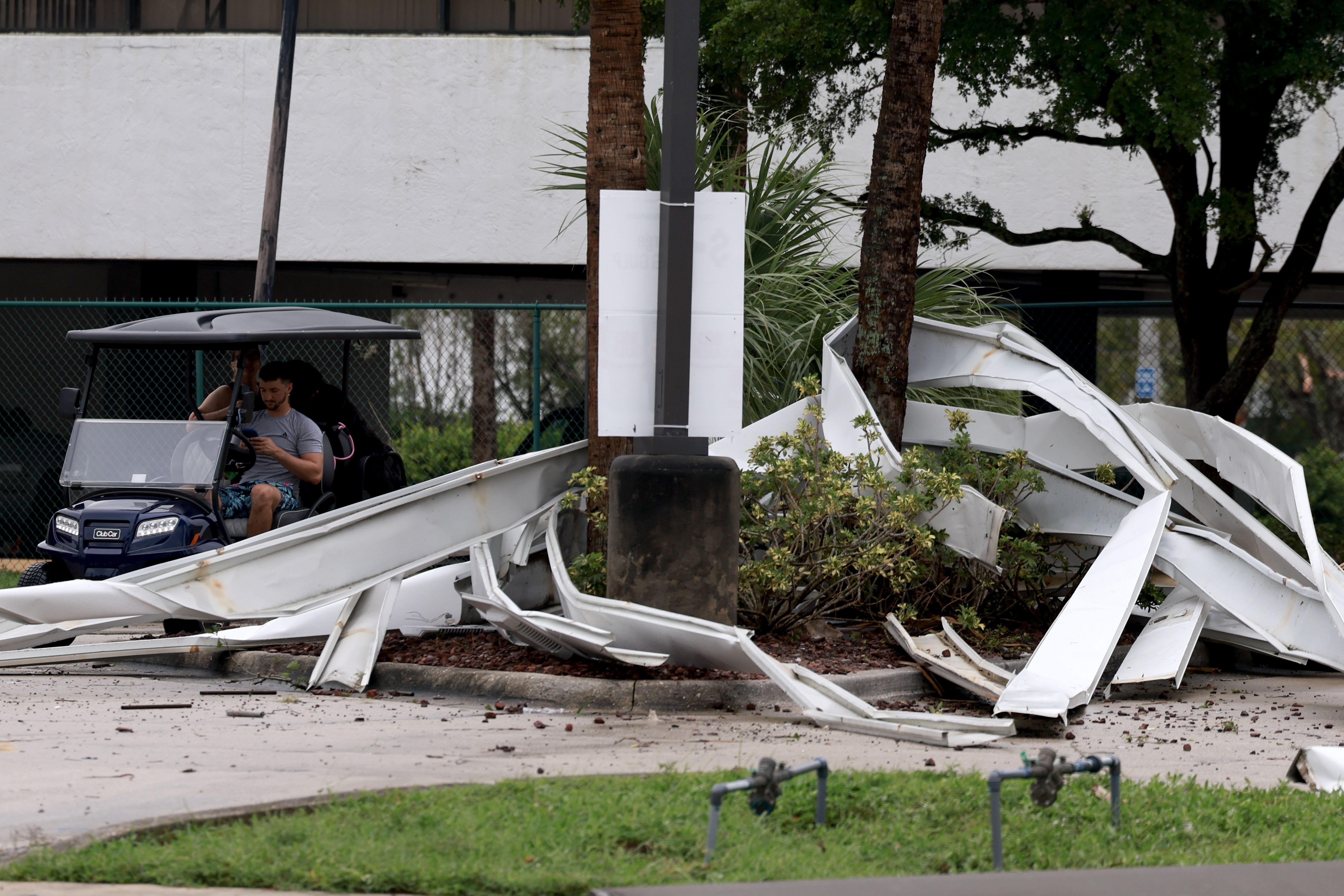 FORT MYERS BEACH, FLORIDA - OCTOBER 09: Metal roofing from a gas station lays in a pile after what appeared to be a tornado passed through the area before Hurricane Milton's arrival on October 09, 2024, in Fort Myers, Florida. People are preparing for the storm, which could be a Cat 3 when it makes 