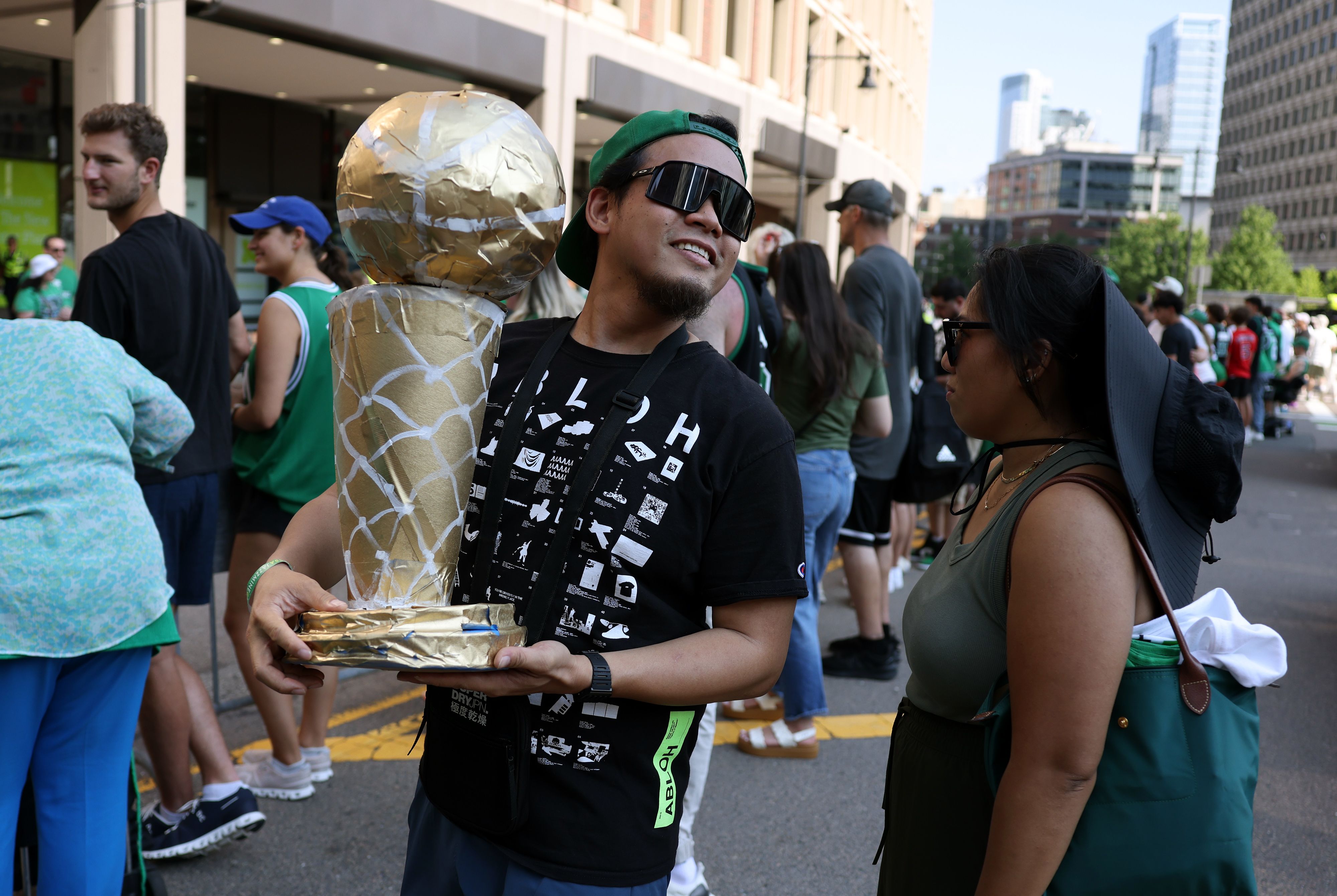Boston, MA - June 21: A man held a homemade trophy before the start of a duck boat parade to celebrate the 18th Boston Celtics NBA championship.
