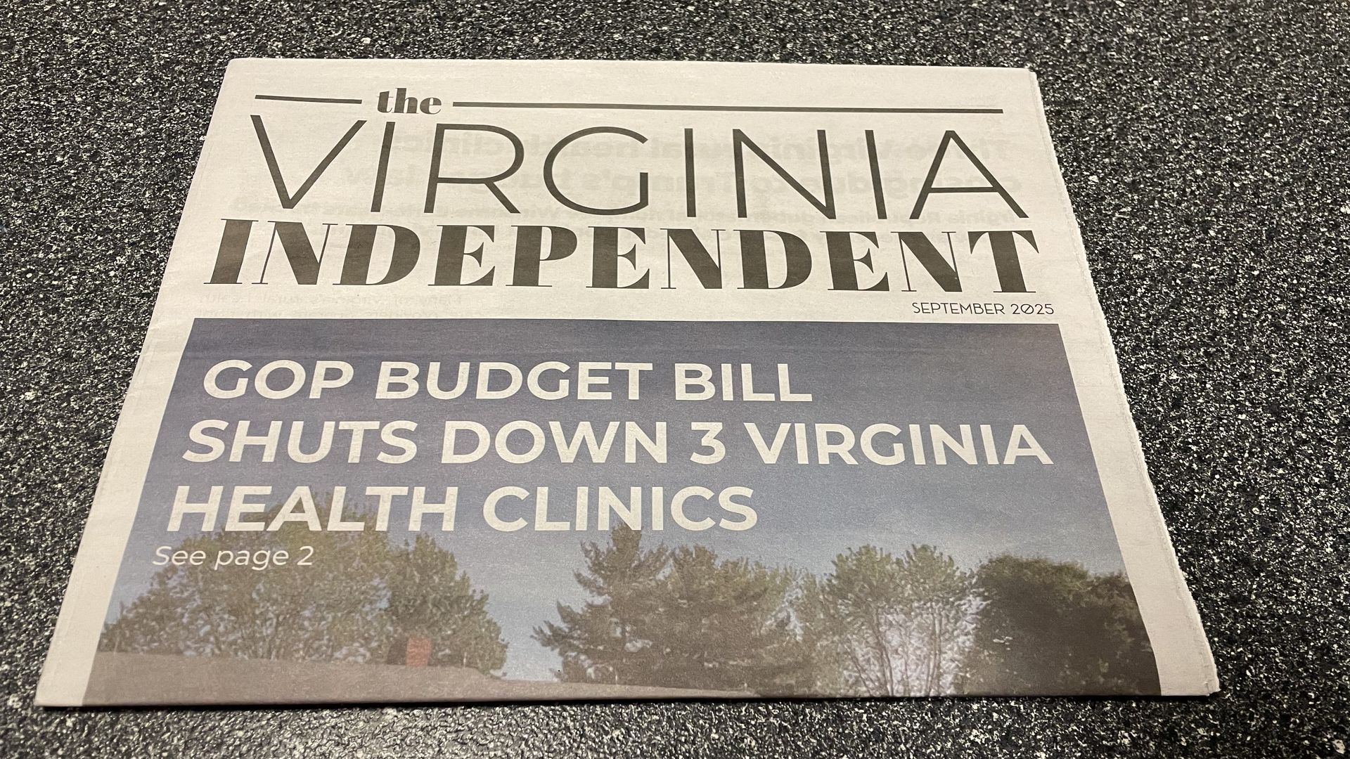 a newspaper folded in half that says The Virginia Independent with a headline that says GOP Budget Bill shuts down 3 virginia health clinics  