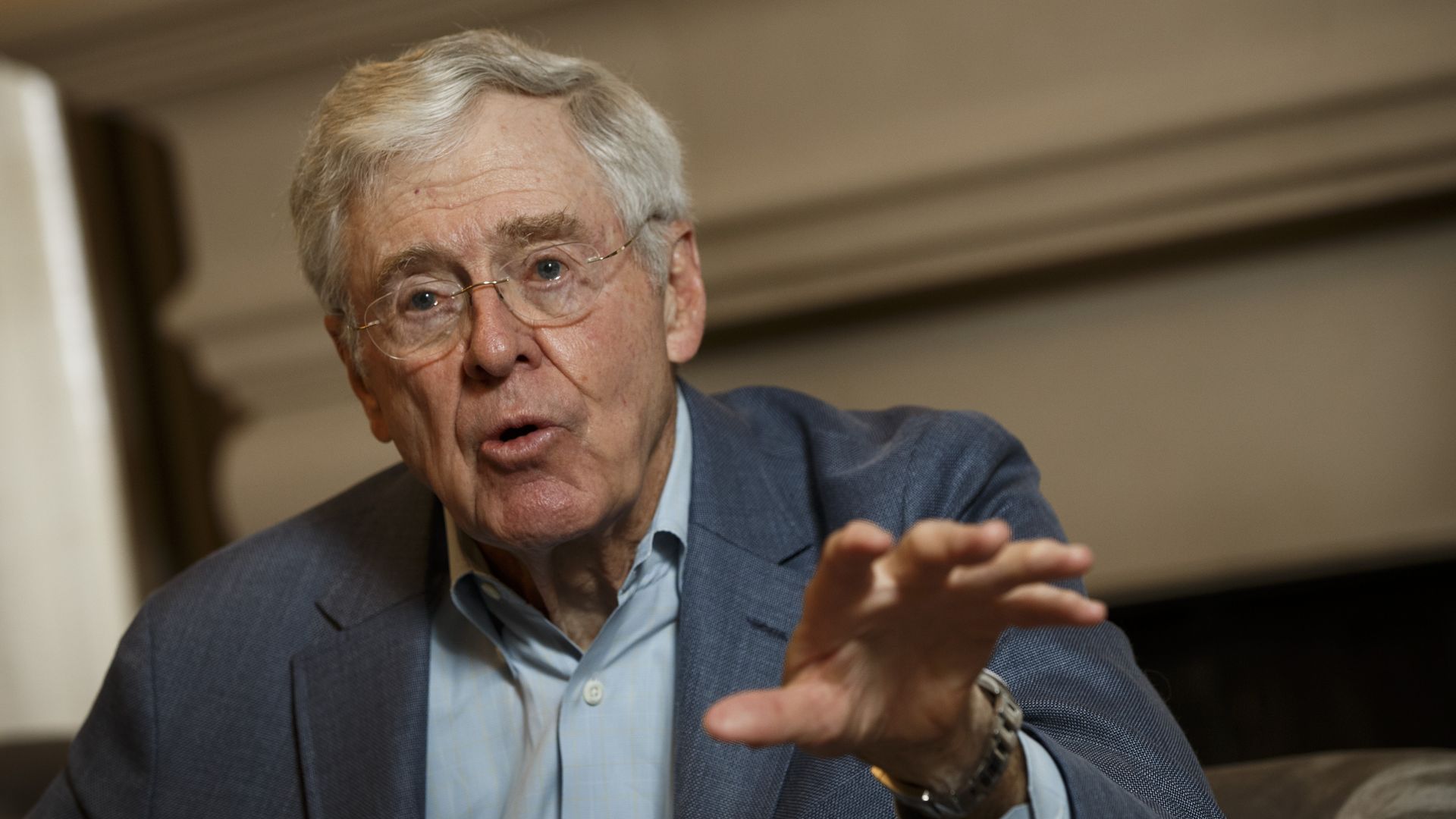 Charles Koch speaking, gesturing outward with his left hand