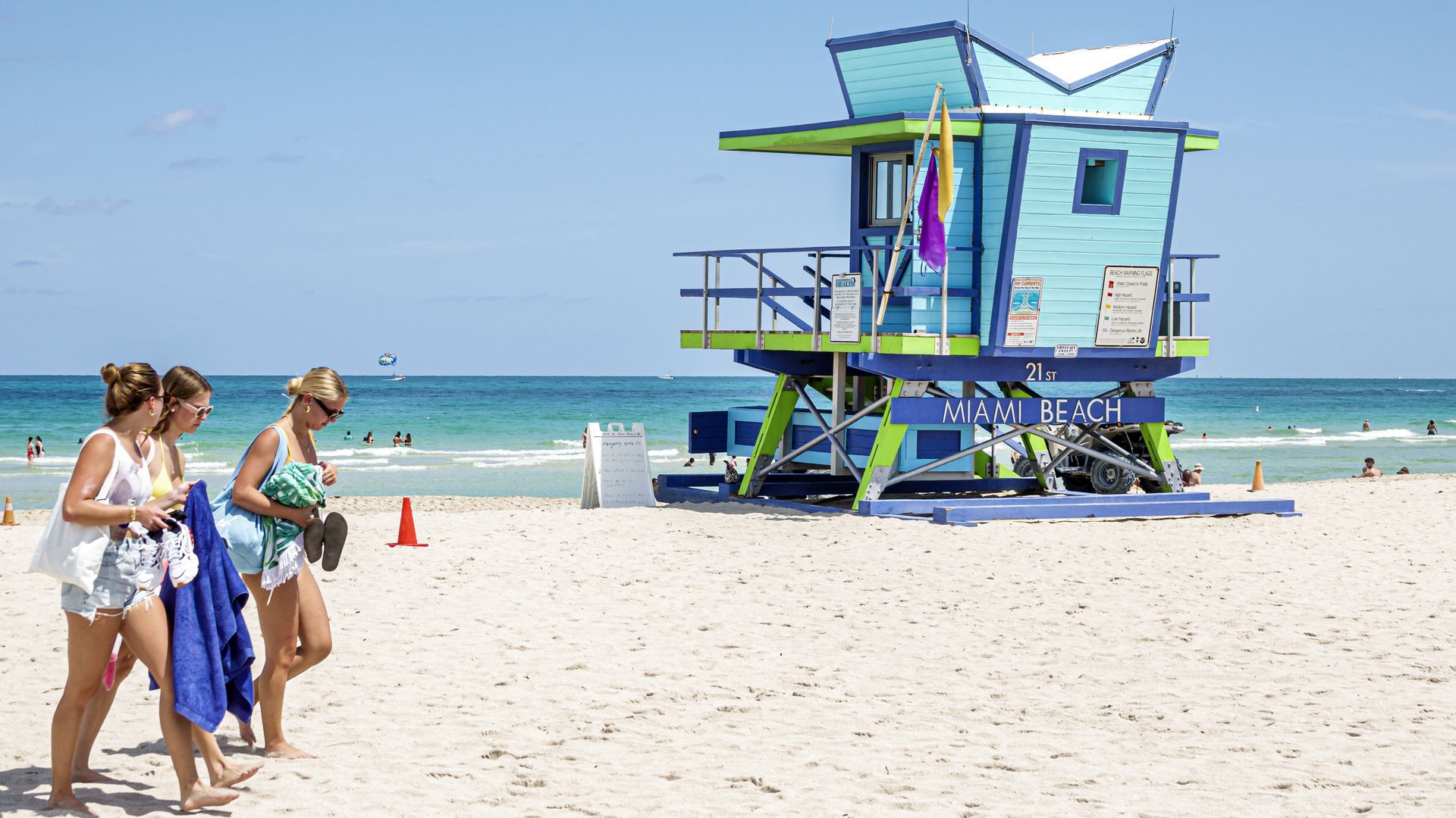 Three women walking by a lifeguard hut on Miami Beach.