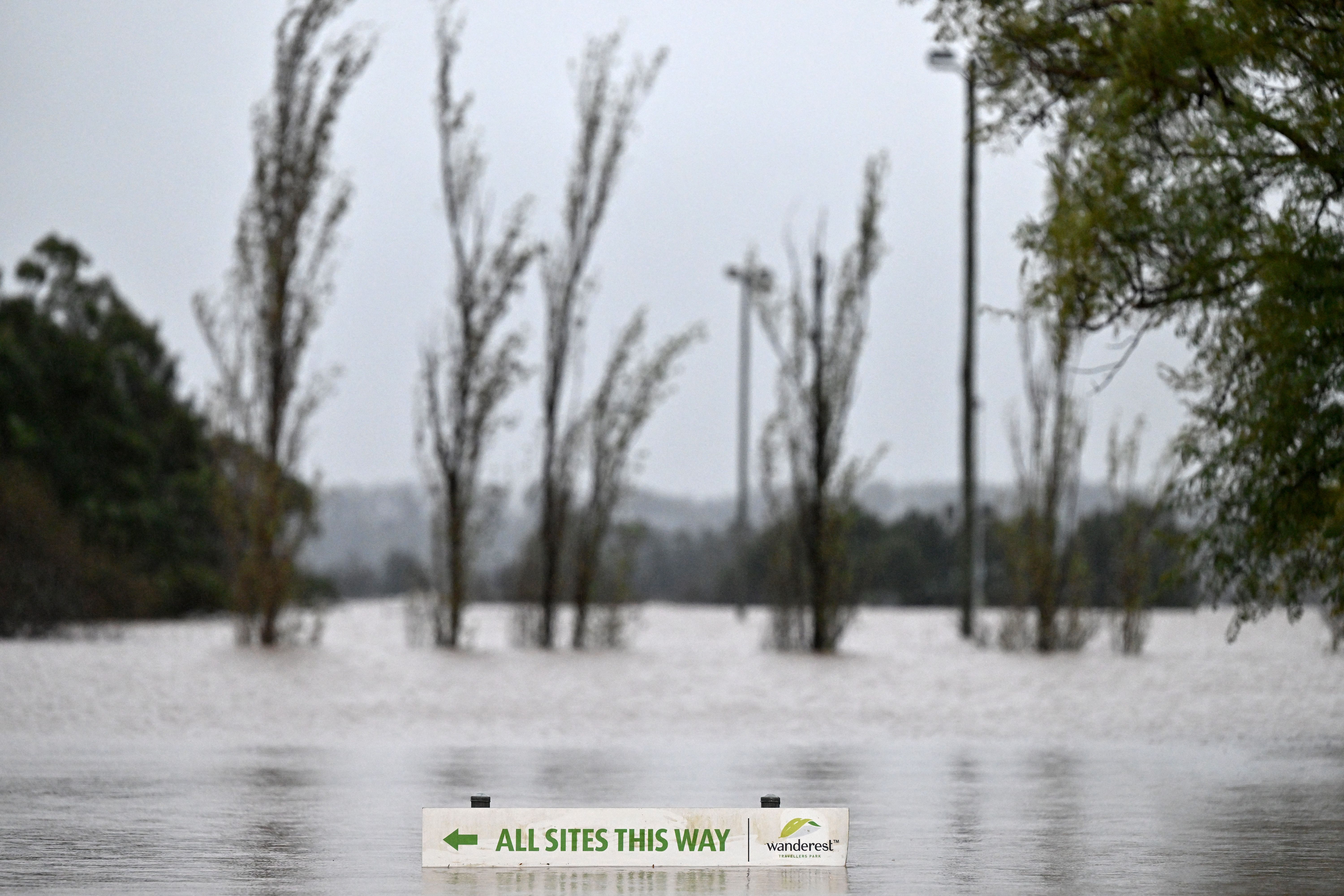 A general view shows a submerged road sign.