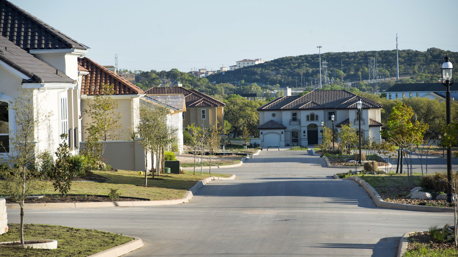 A home in a suburban neighborhood sits far away down the street, with the edges of other homes popping into the peripheral.