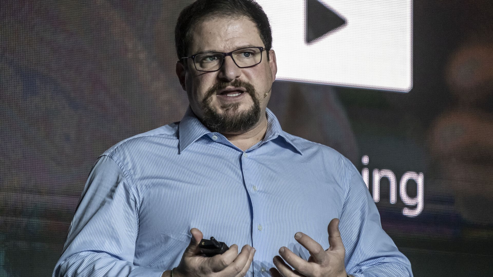 A man presents in a blue collared shirt