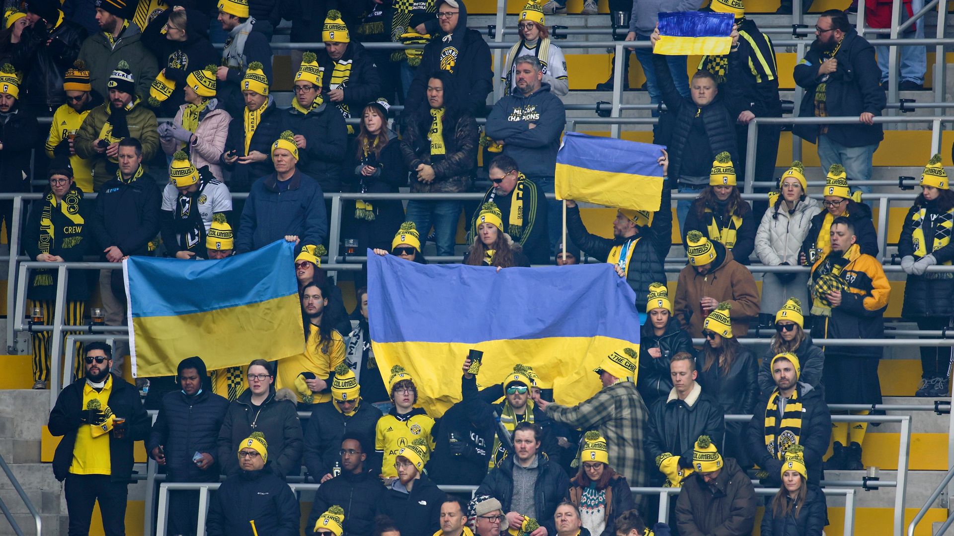 Crew fans hold up Ukraine flags in the stands