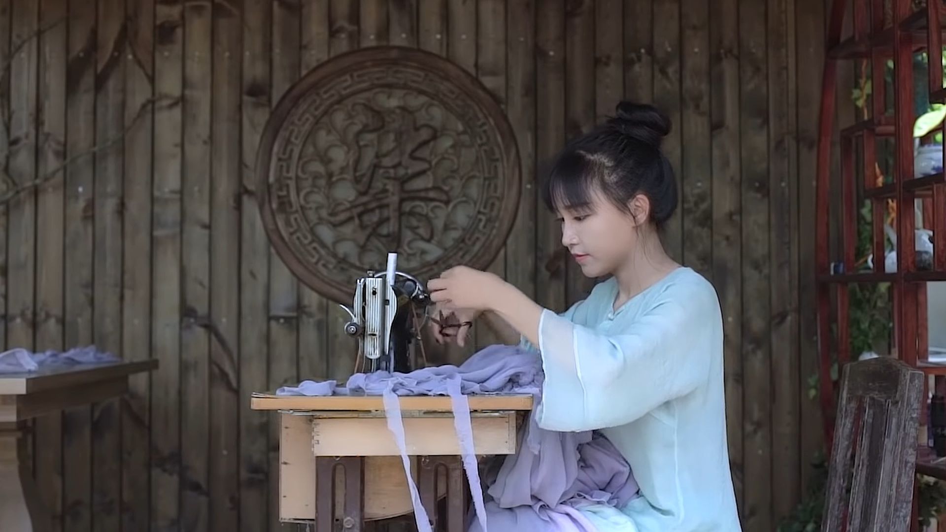 Li Ziqi is sewing in a room with tradition Chinese decorations