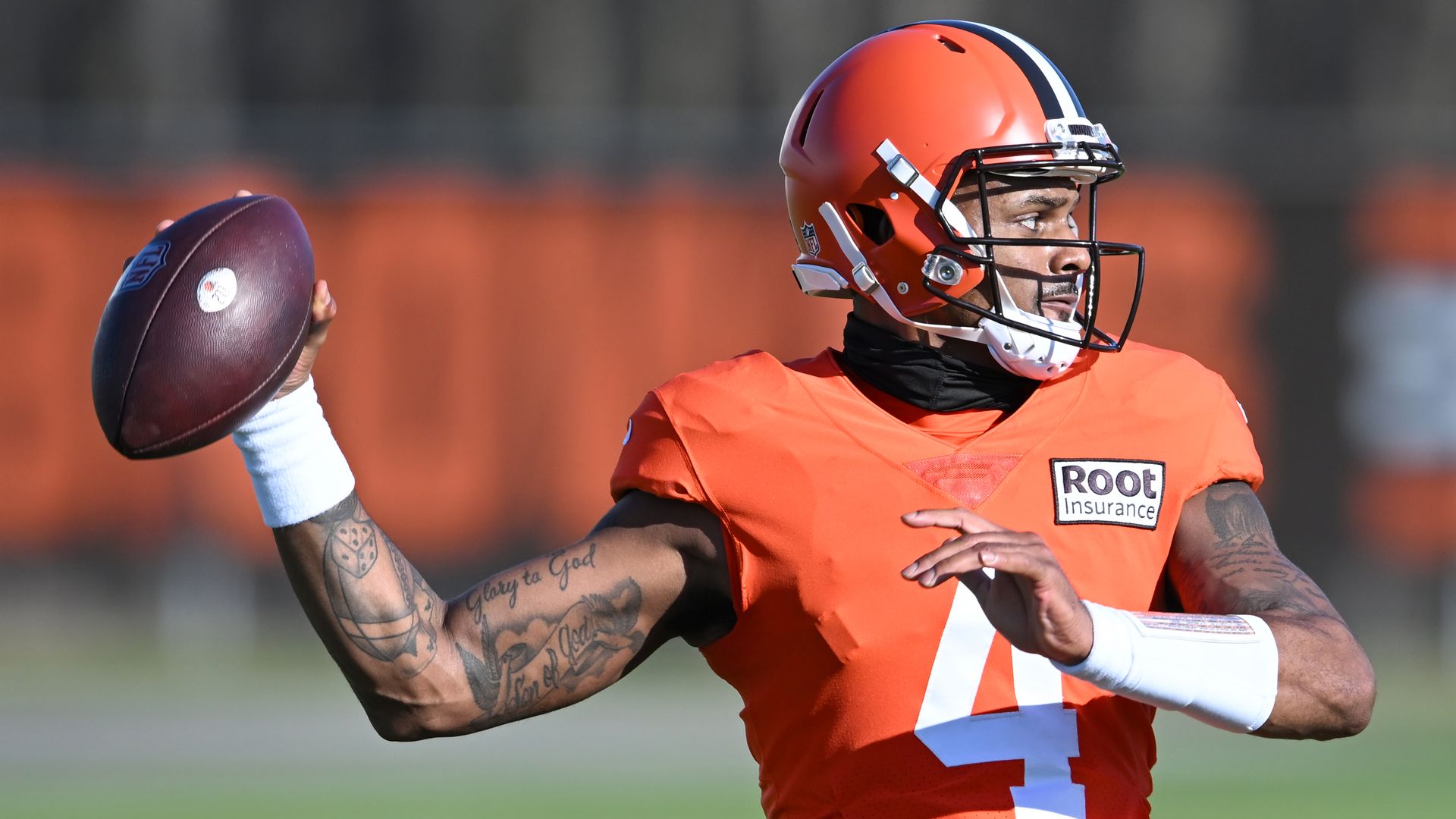 Browns quarterback Deshaun Watson, wearing an orange football jersey and orange helmet, prepares to throw a football 