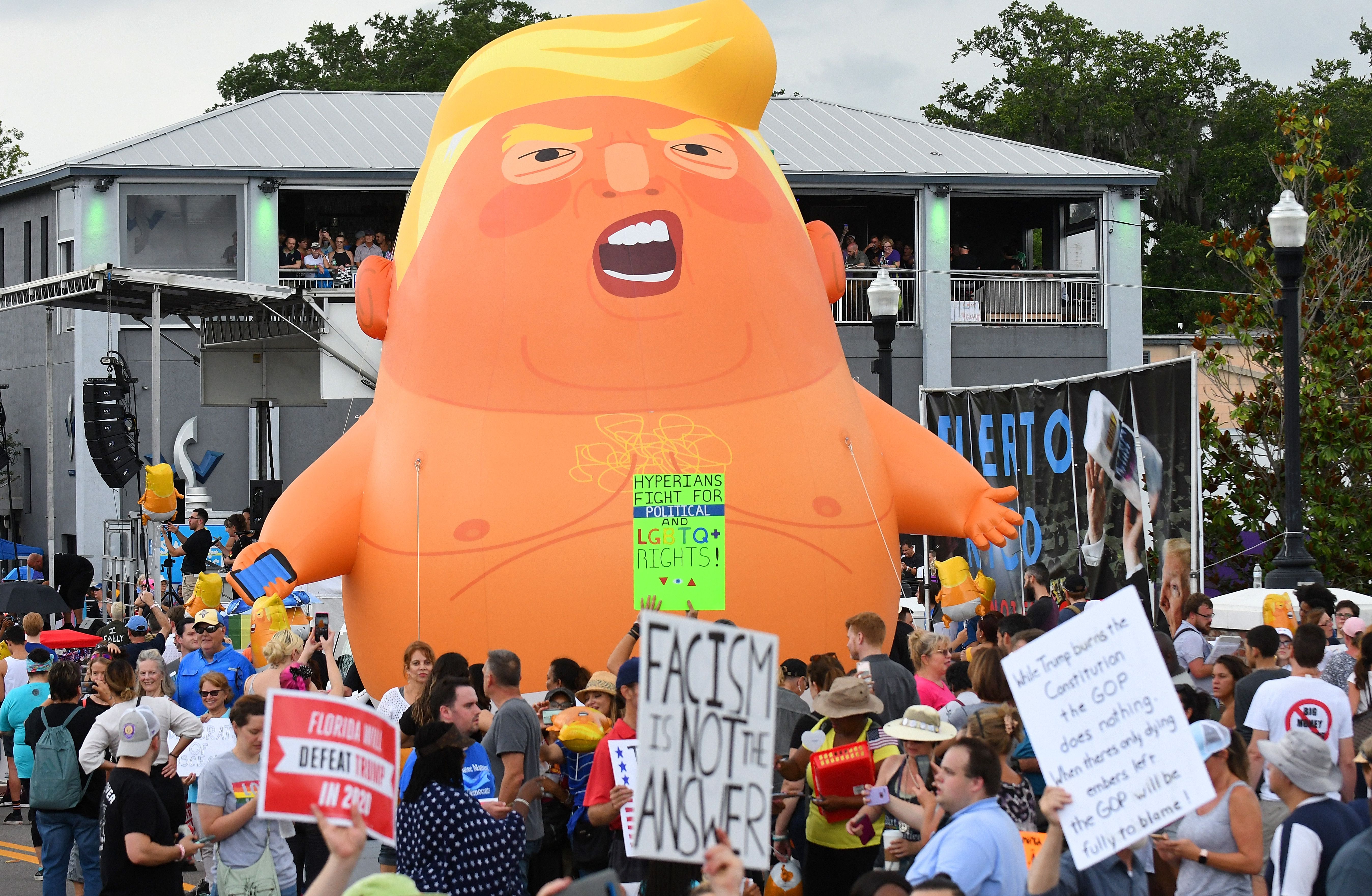  Anti-Trump protesters gather around a huge "Baby Trump" balloon outside a rally where President Trump officially launched his re-election campaign on June 18, 2019 in Orlando, Florida. 