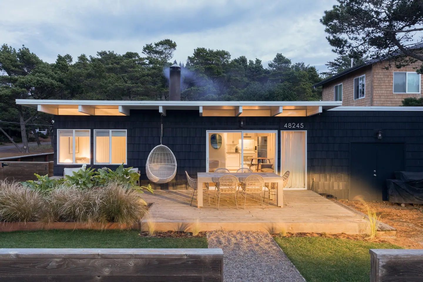 A photo of the exterior of a home at night with all of the lights turned on.