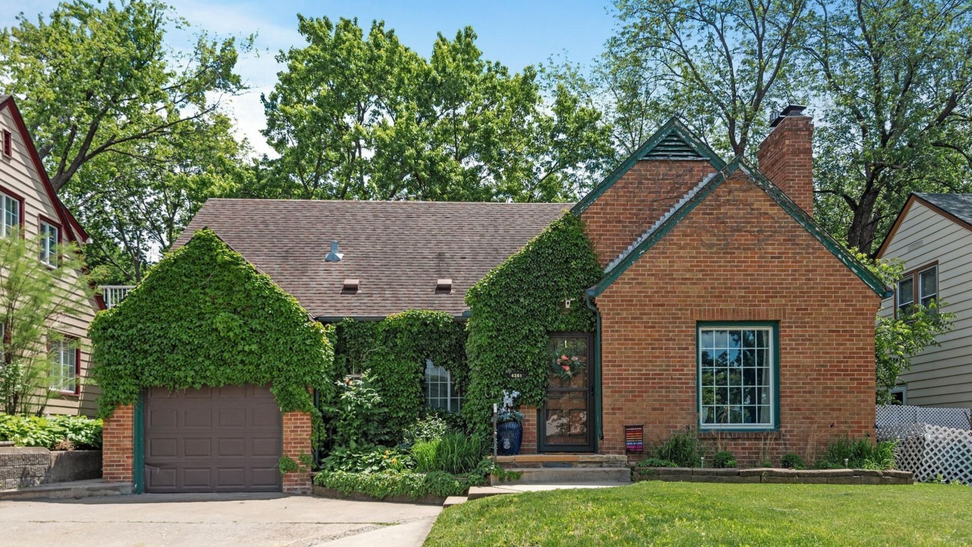 home with brick exterior with greenery