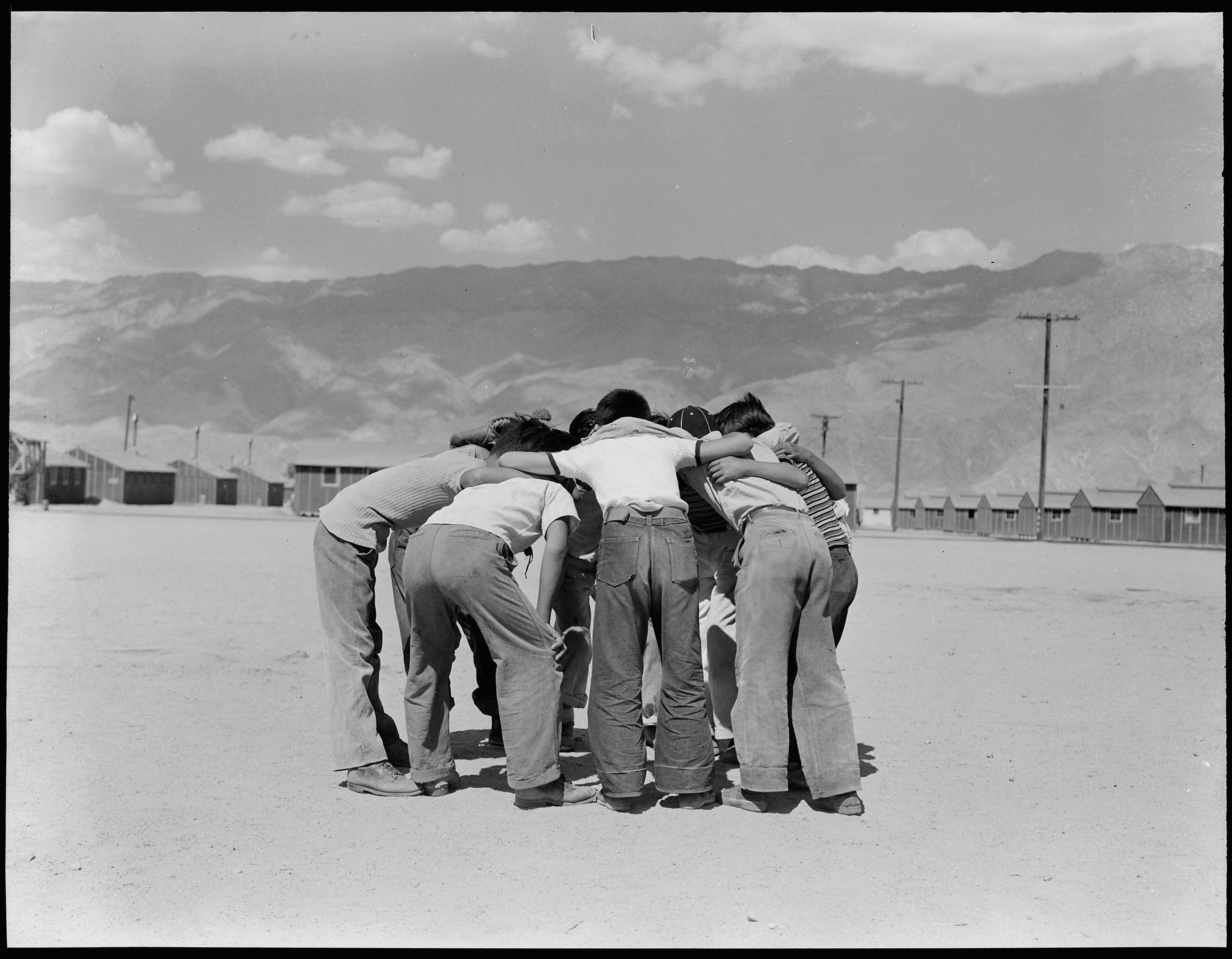 Boys huddle during a softball game.