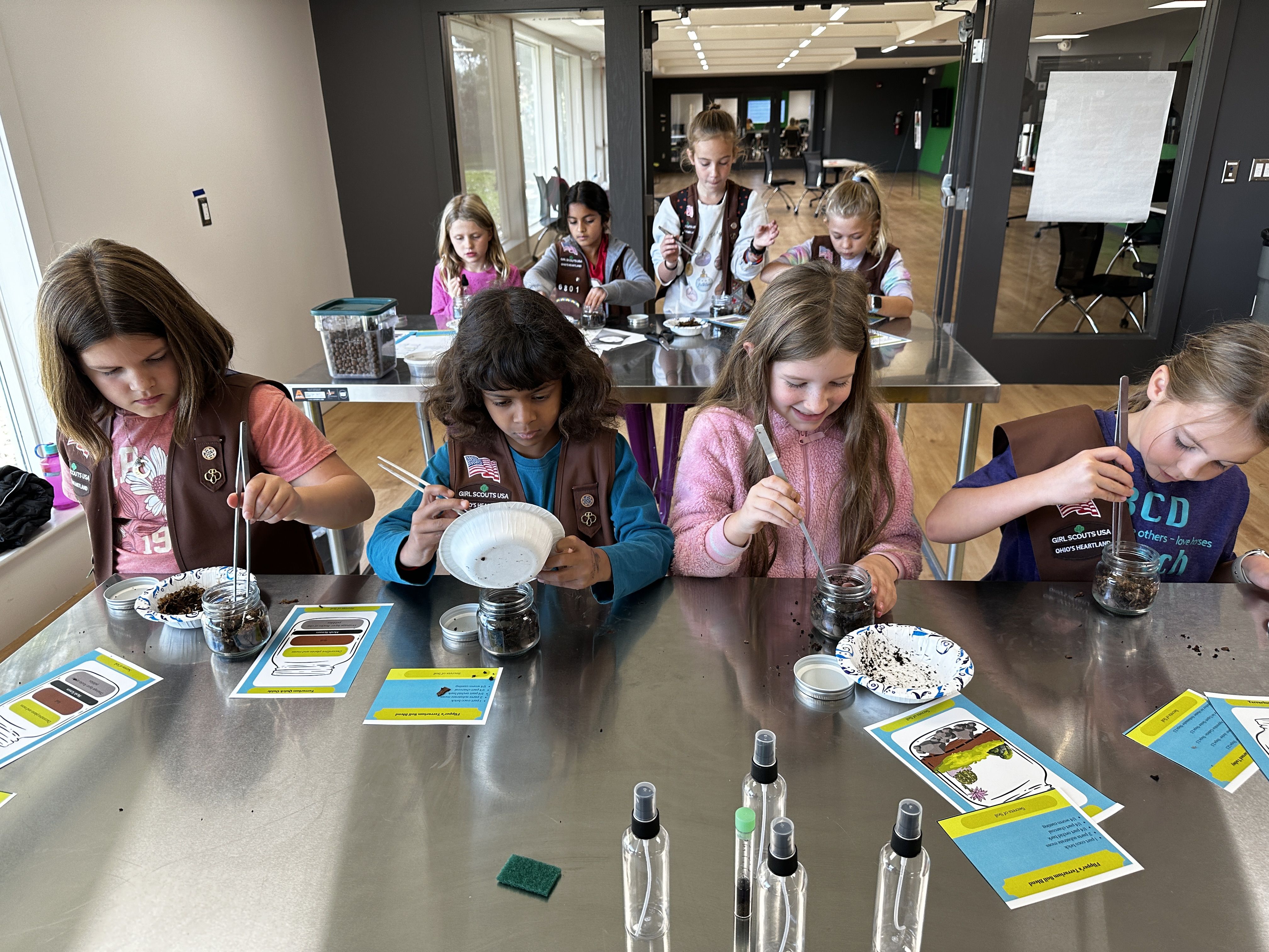 Four Girl Scouts experiment with soil composition in a lab