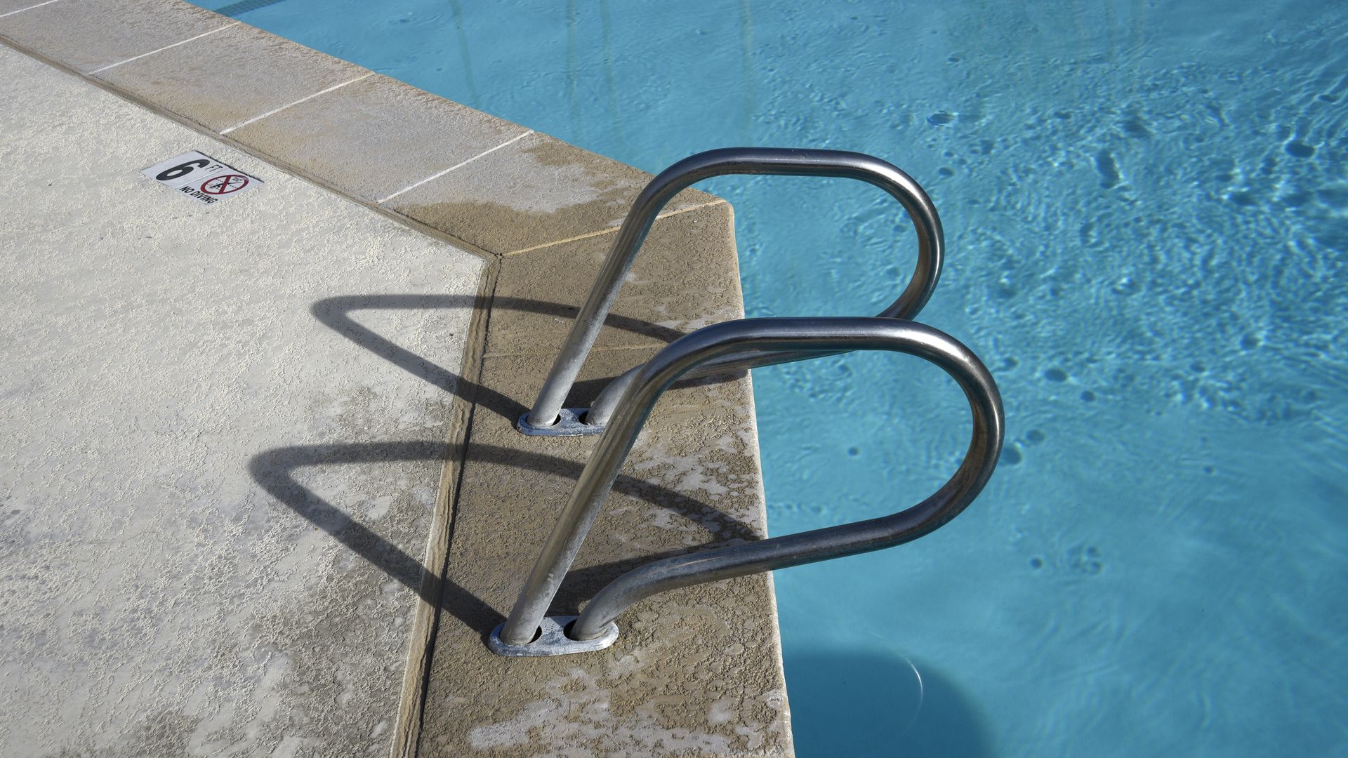 Photo of handrails leading into a swimming pool