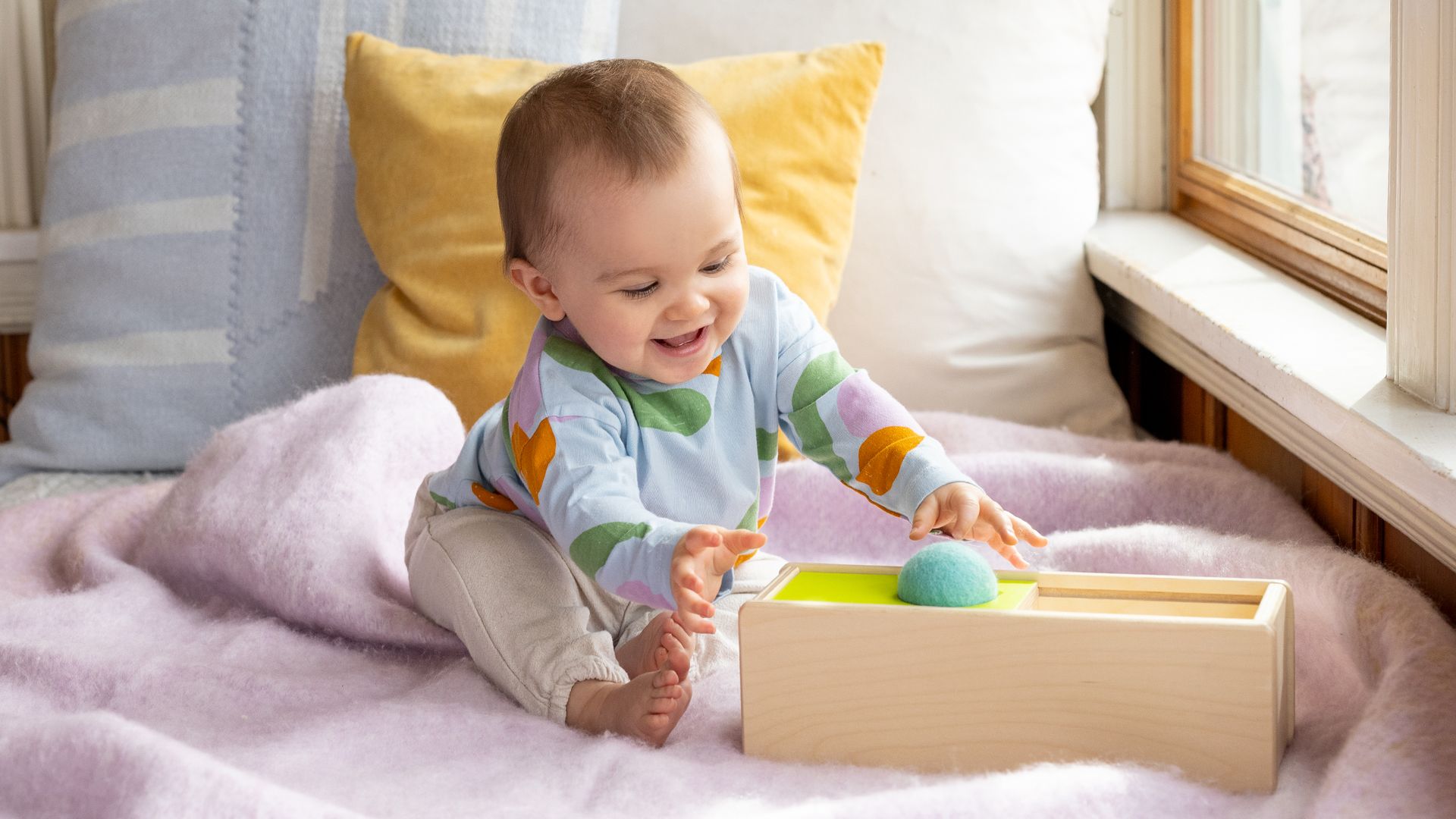 A baby interacts with a child development toy sold by Lovevery.