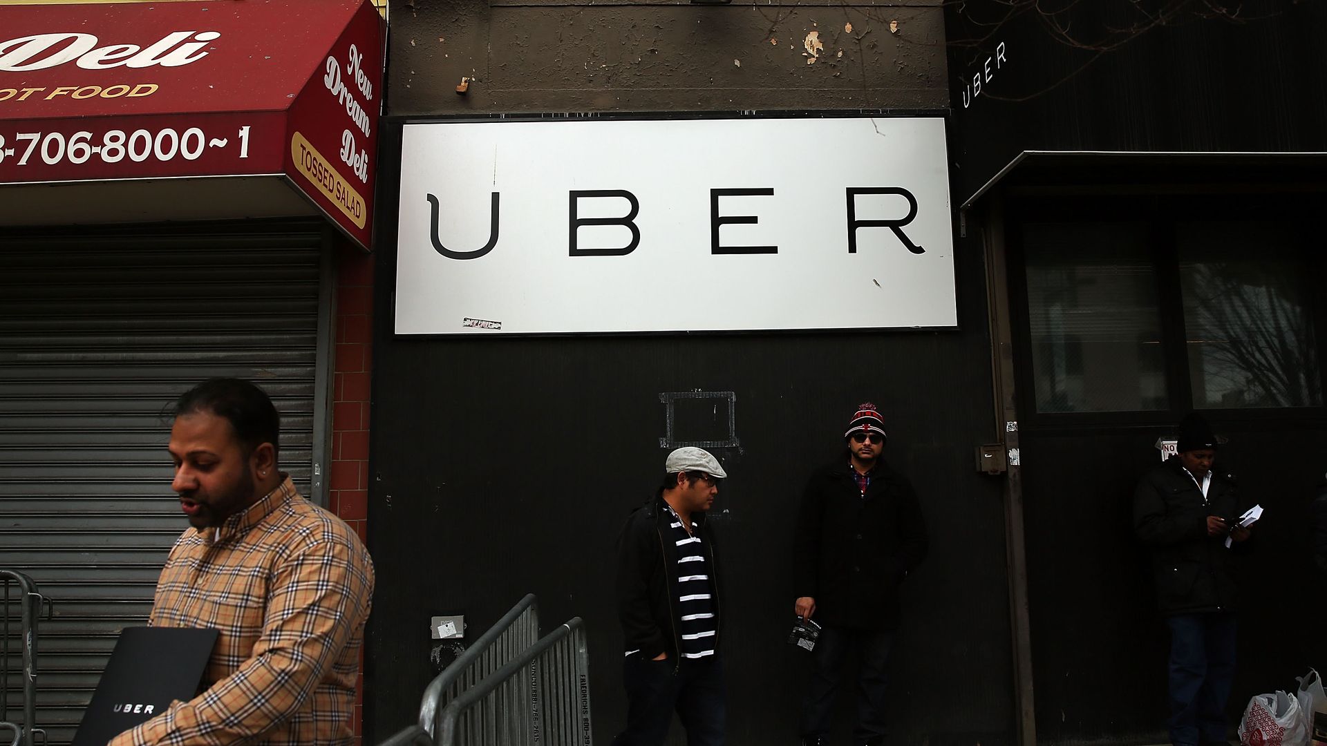 Men standing under a white Uber sign