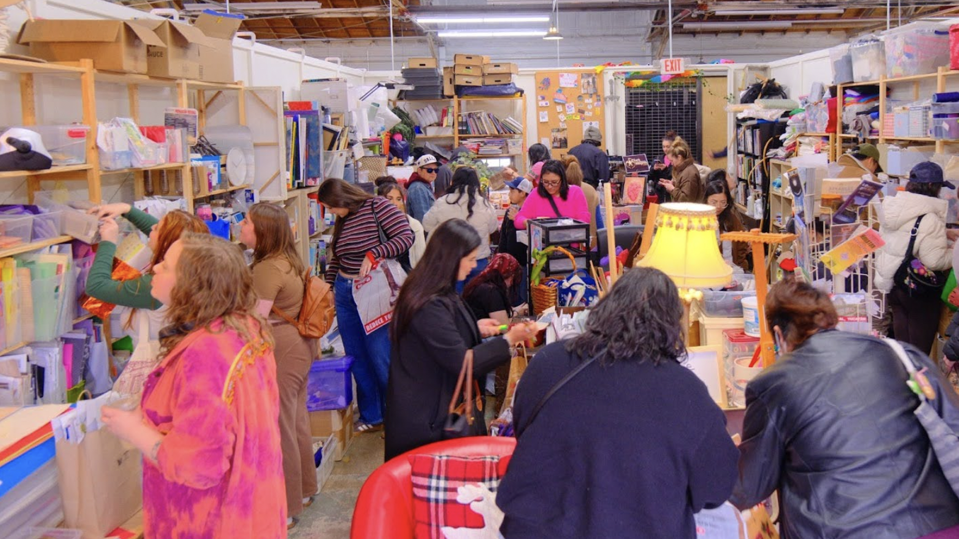 Over a dozen people browse the shelves of a craft store