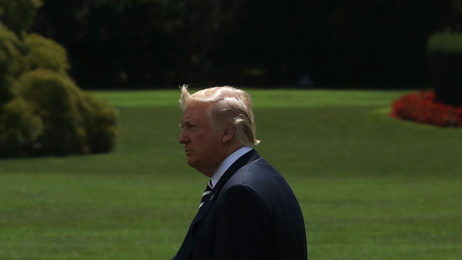 Donald Trump walking outside with his hair being blown up in the wind