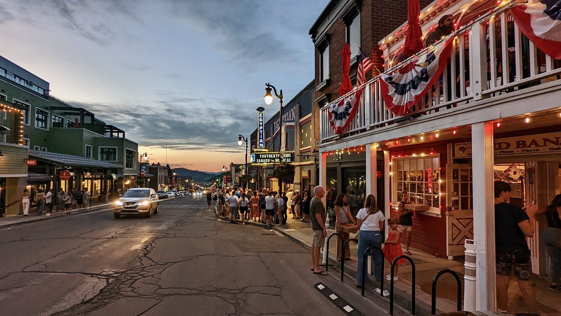Crowds and cars explore Park City's Main Street as the sun sets.