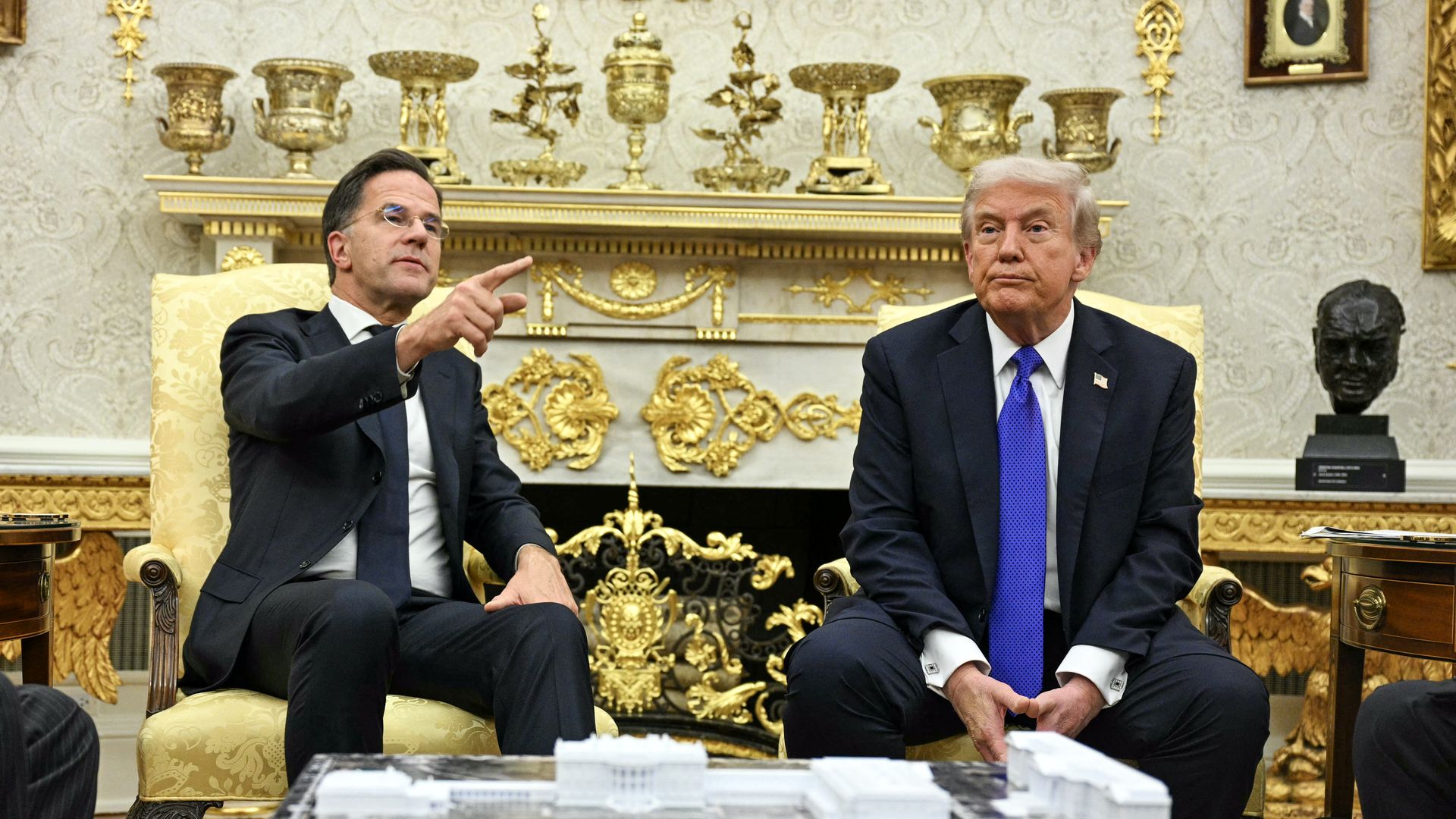 照片中，川普總統與北約秘書長馬克‧呂特在橢圓形辦公室，身後擺放著各種金色裝飾品和獎盃。