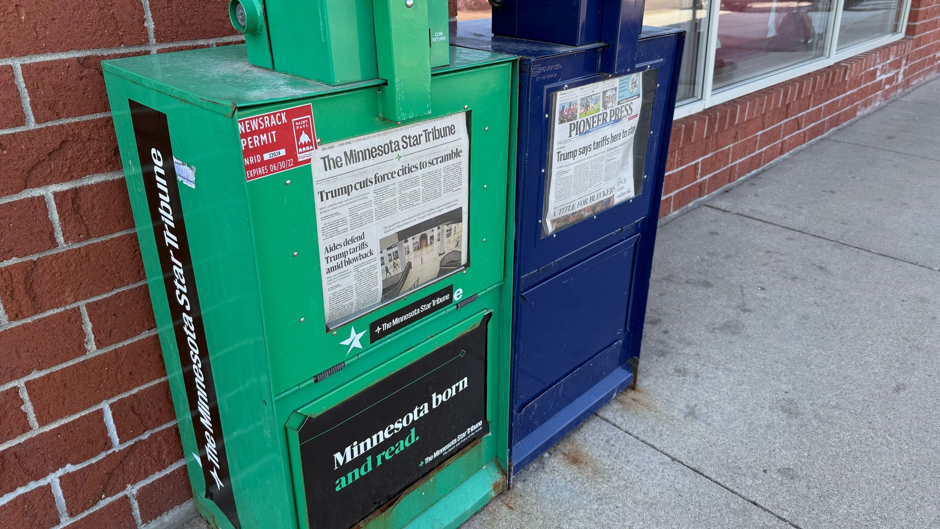 A photo of a Star Tribune newspaper box next to a Pioneer Press one 