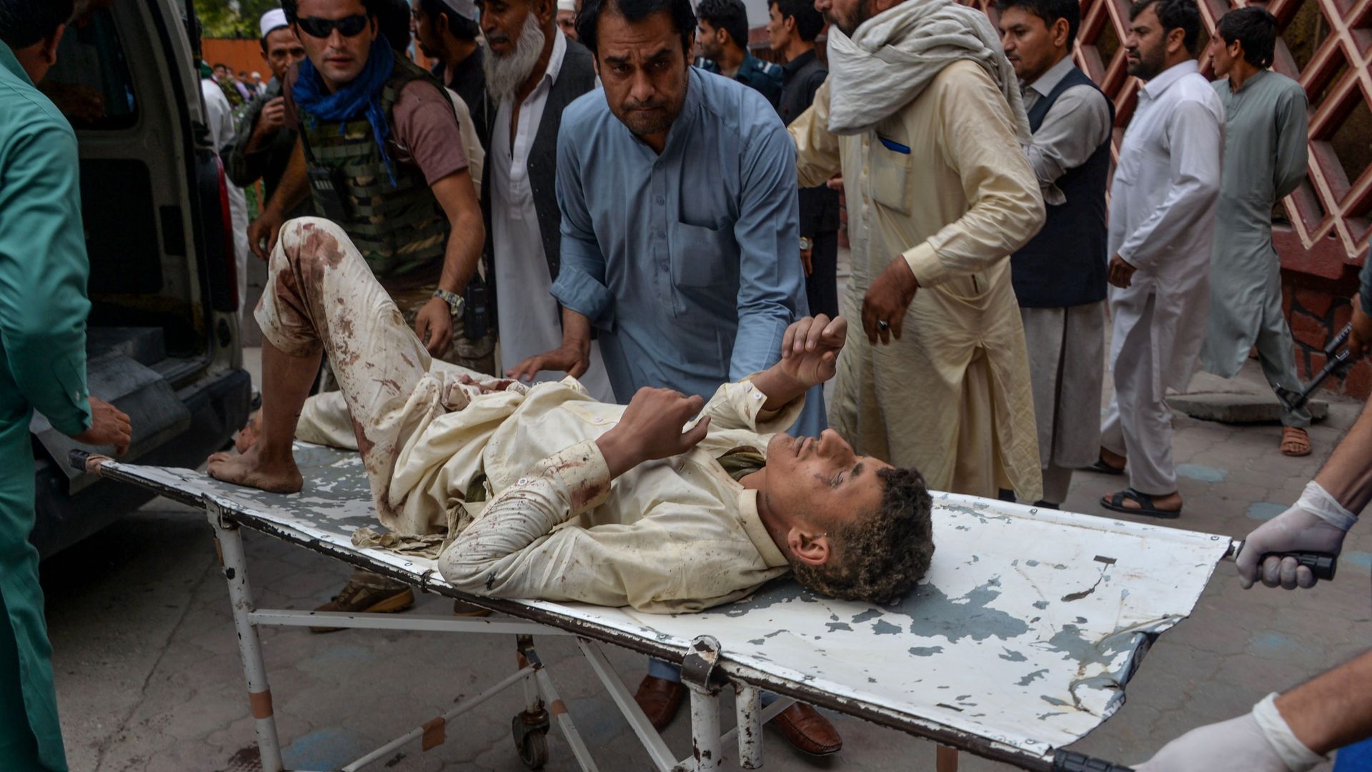 A man wounded from an attack in Afghanistan is carried by volunteers on a stretcher