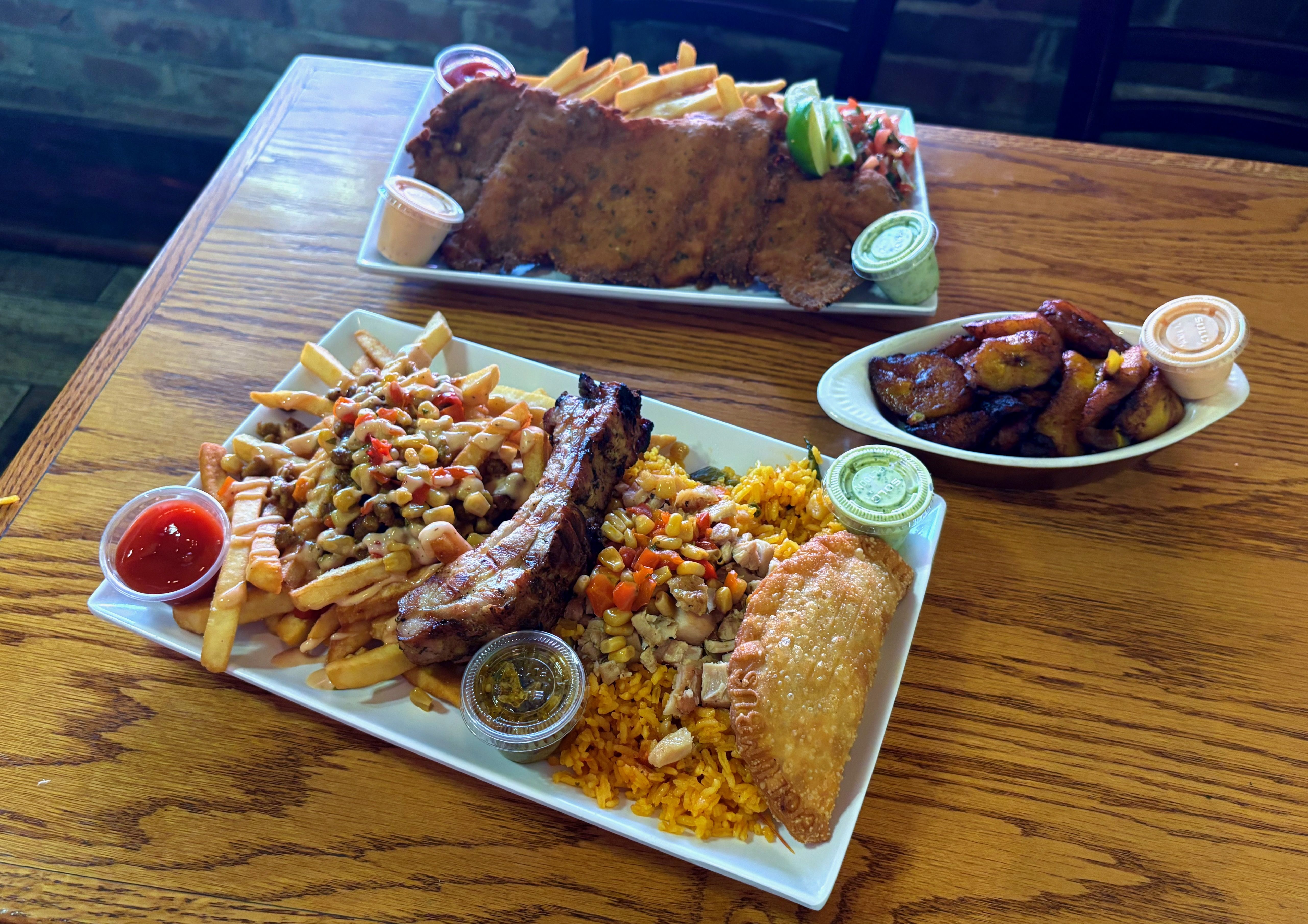An overview of our lunch table, with a sampler platter, plantains and the milanesa grande