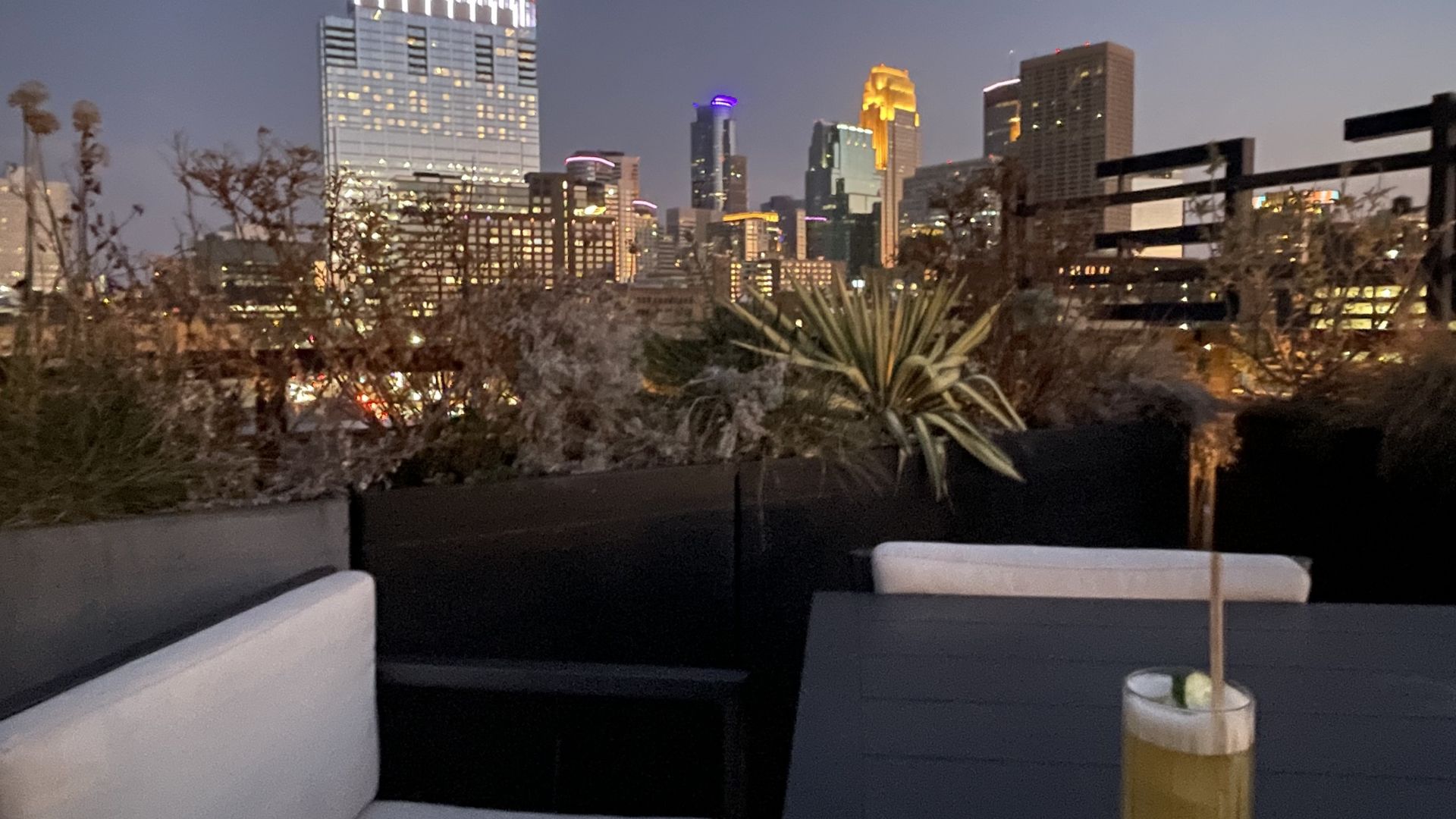 A photo of a cocktail with the downtown minneapolis skyline in the background 