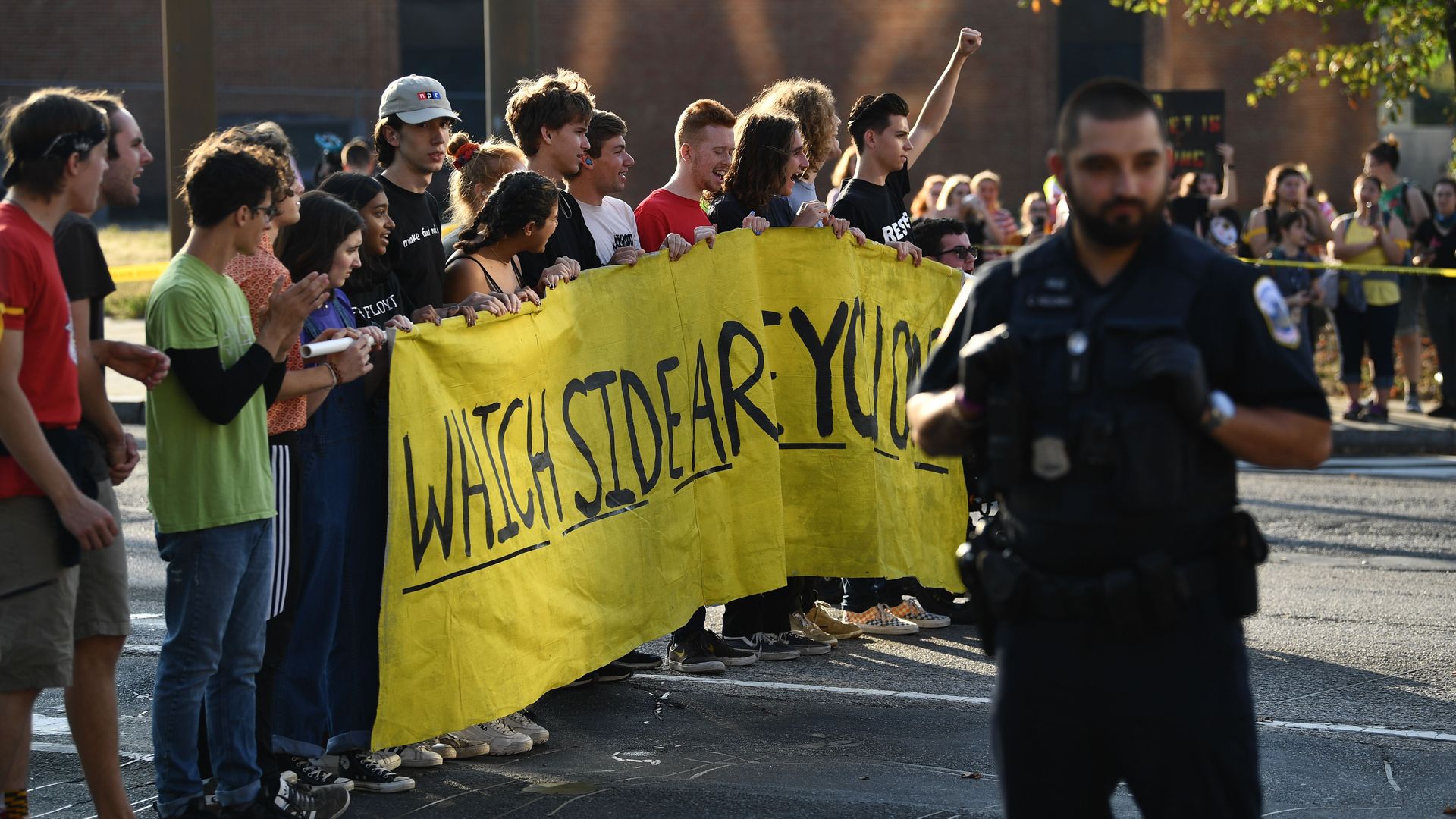 Environmental activists hold a sign in a D.C. street.