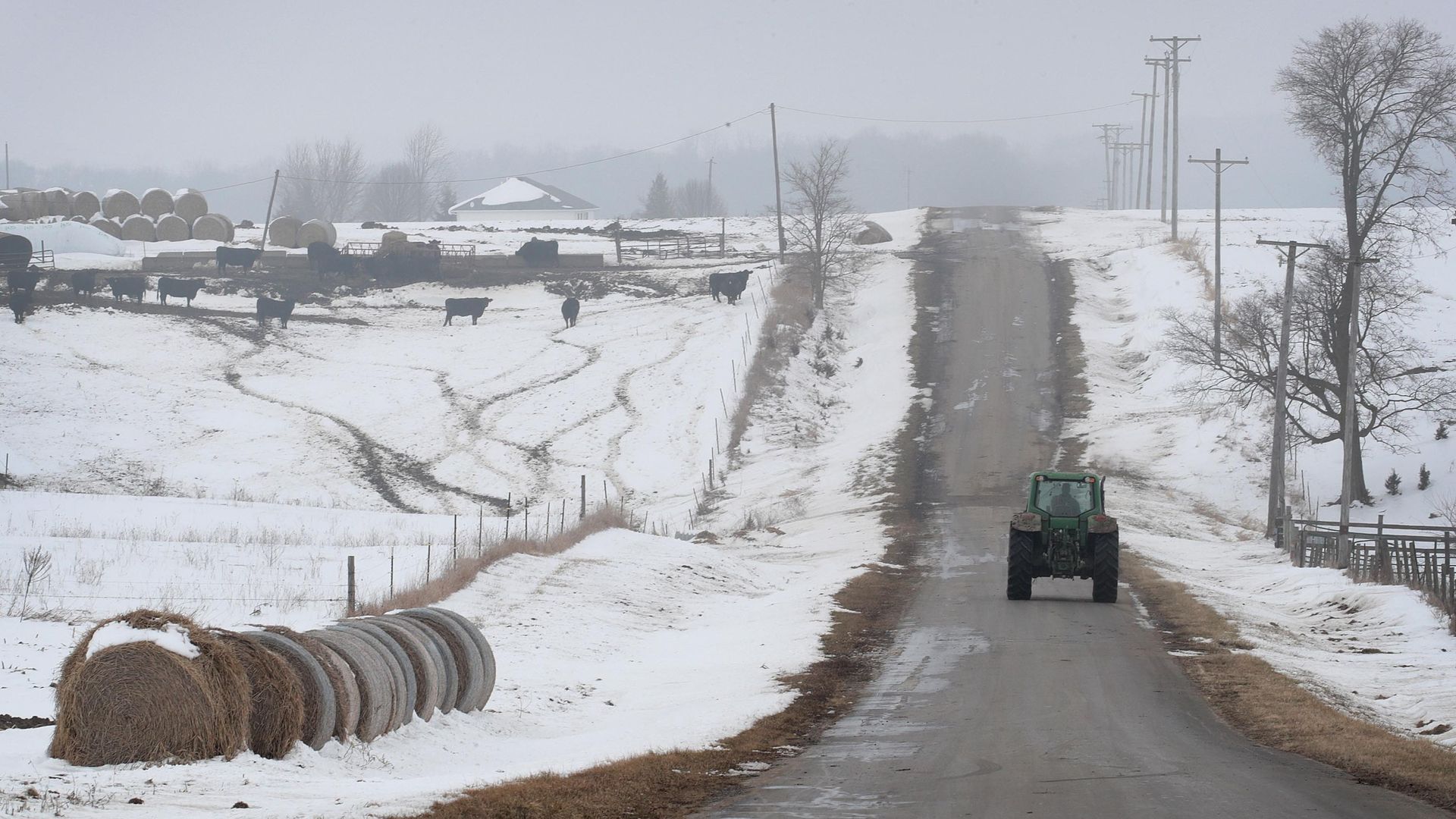 A farmer driving a tractor down the road