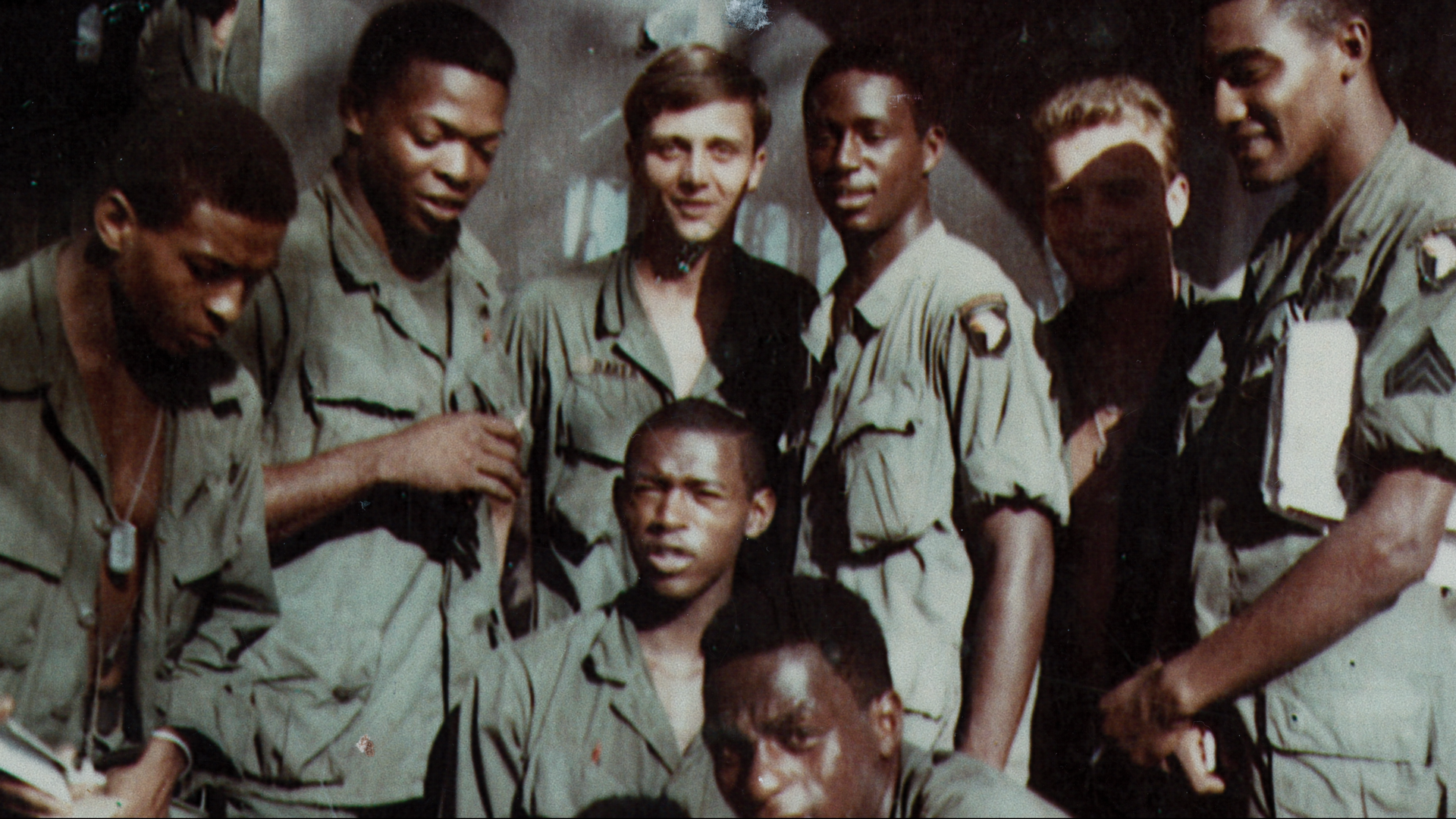 Black and white American soldiers in Vietnam stand for a photo.