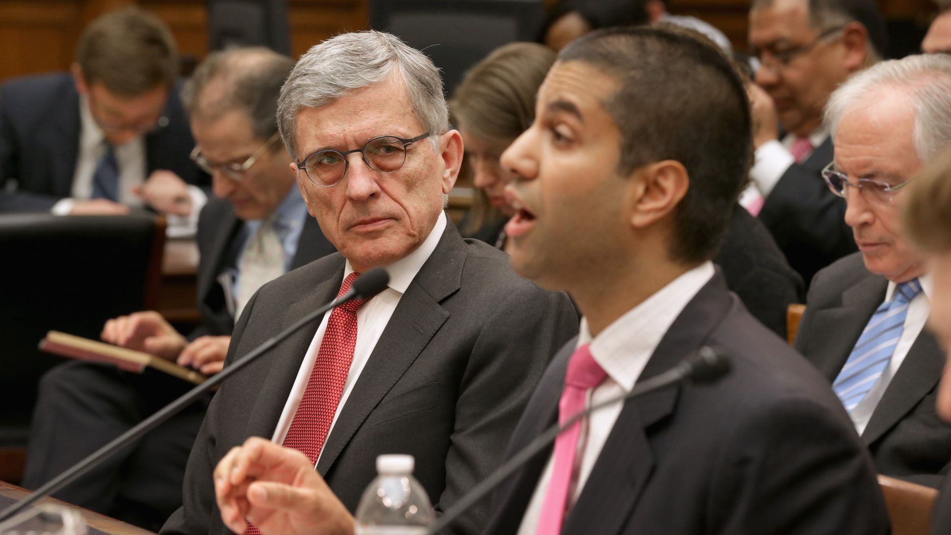 Tom Wheeler looks at Ajit Pai while they both testify