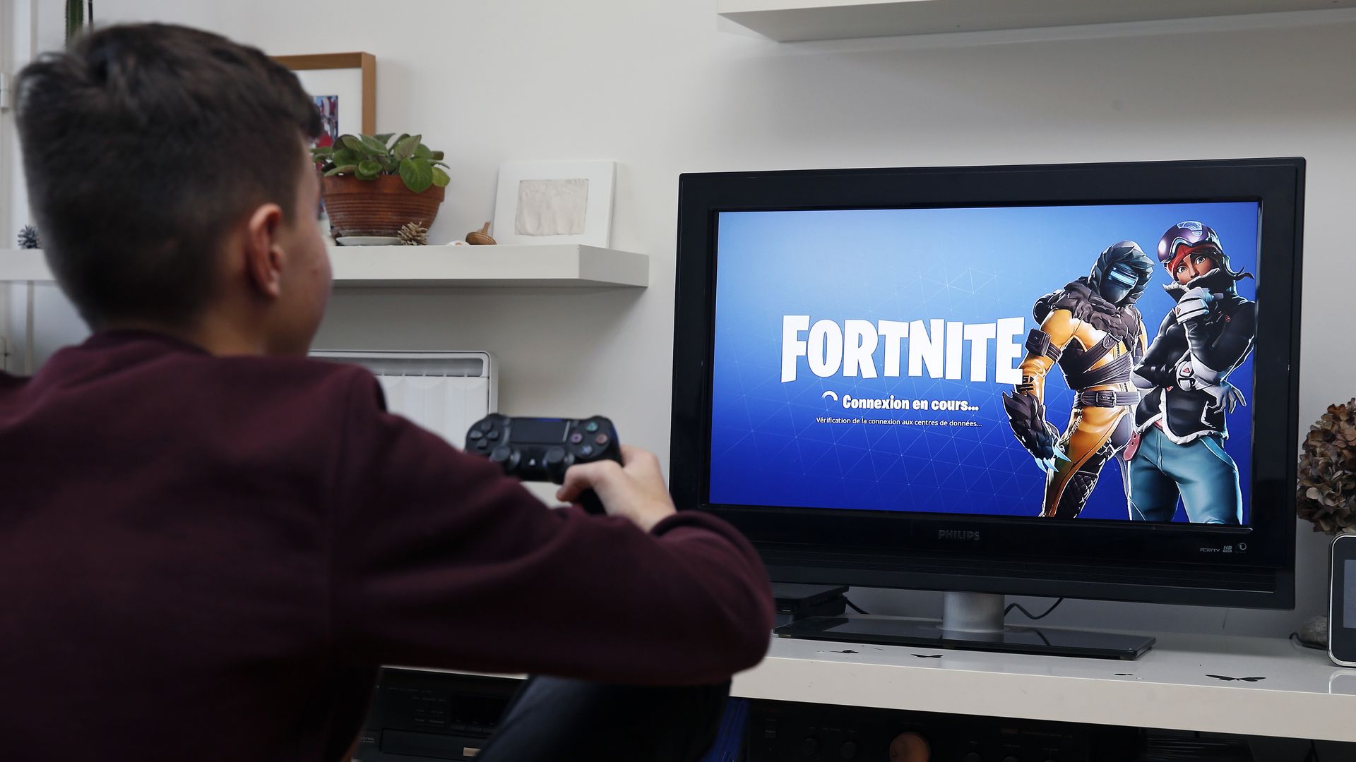 A child playing Fortnite on a TV.