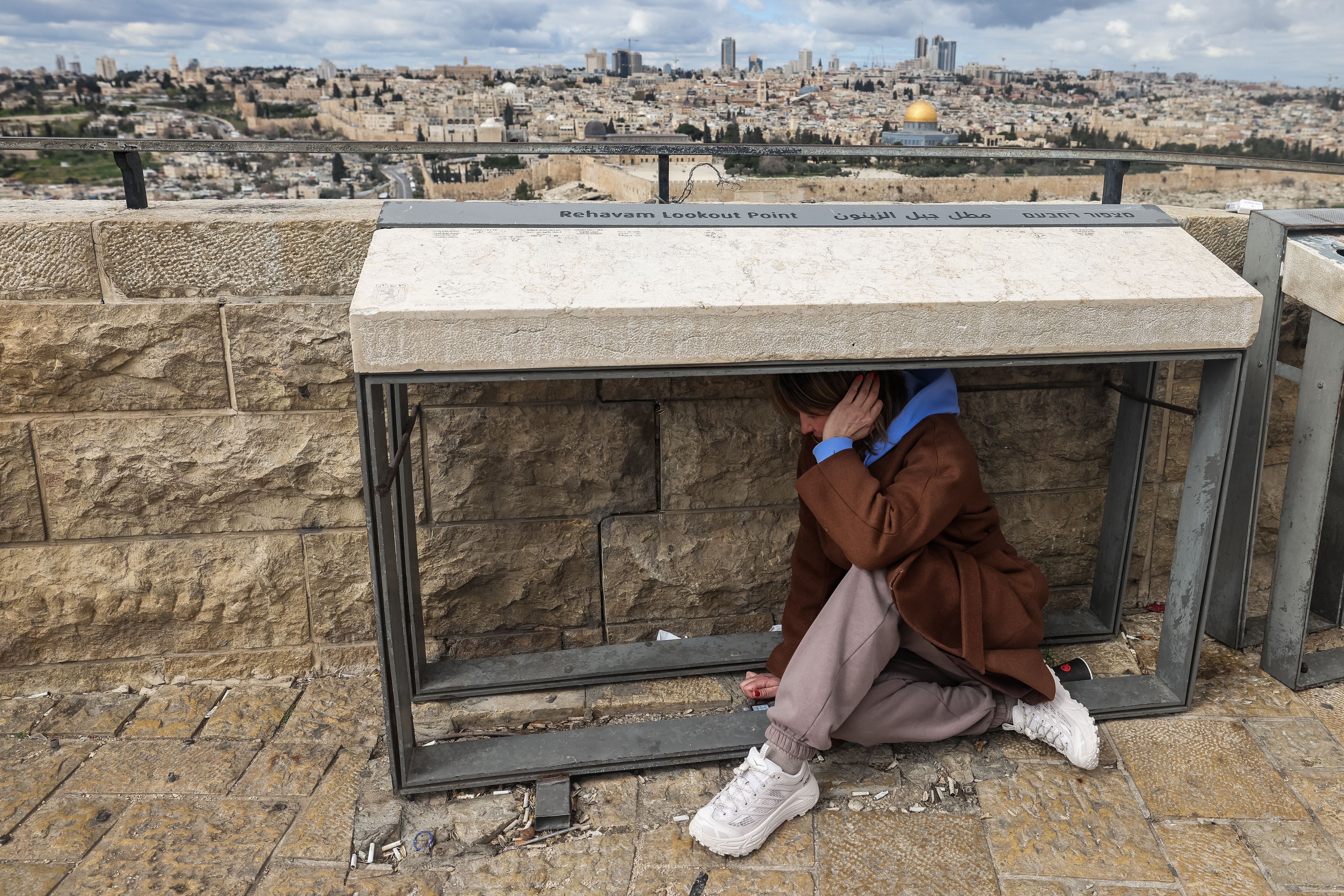 A person takes shelter as sirens sounded in Jerusalem on February 28, 2026, following the announcement that Israel had launched a "preemptive strike" on Iran.