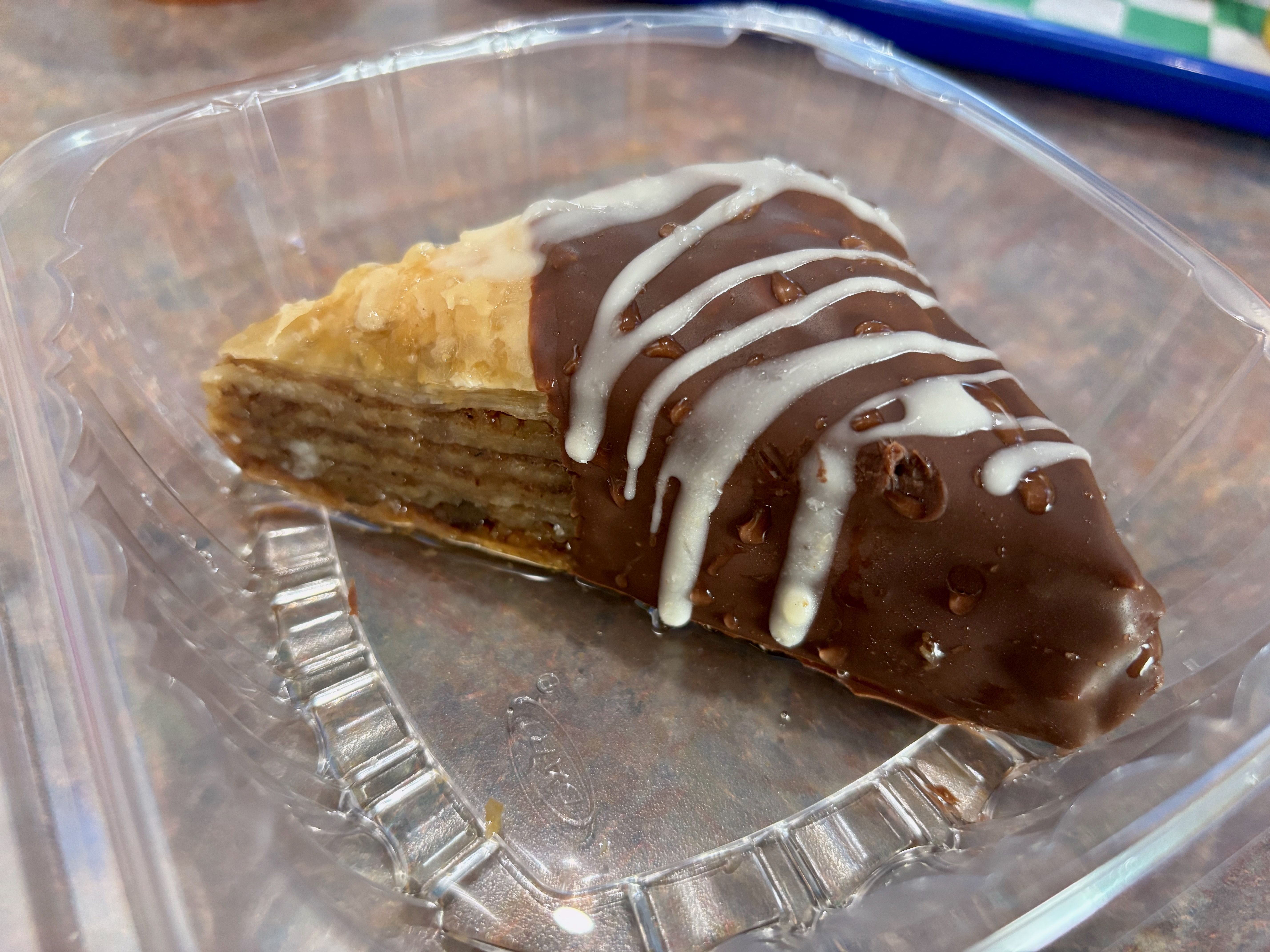 A close-up of a chocolate-dipped baklava dessert