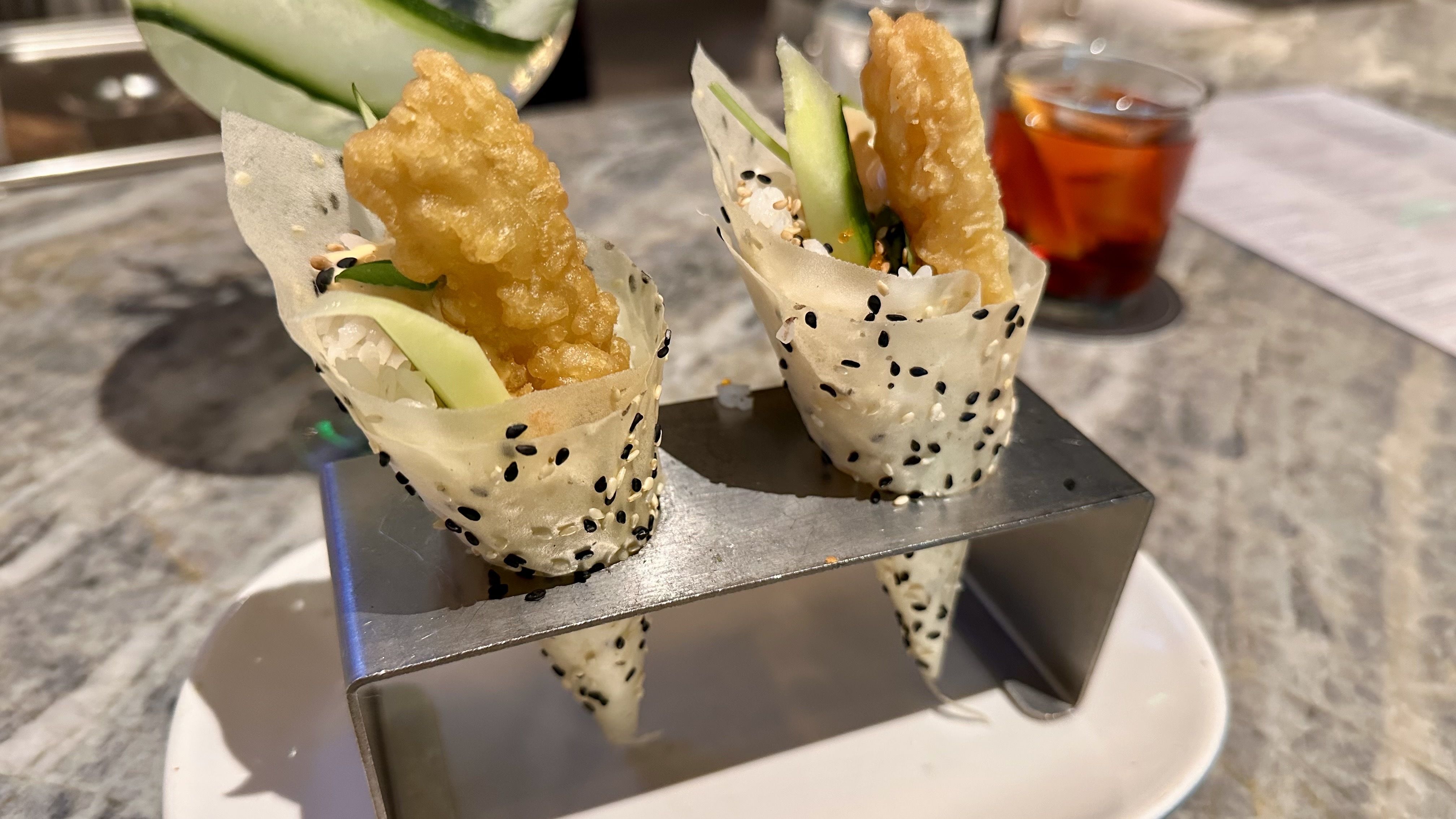 Two thin cones filled with shrimp tempura