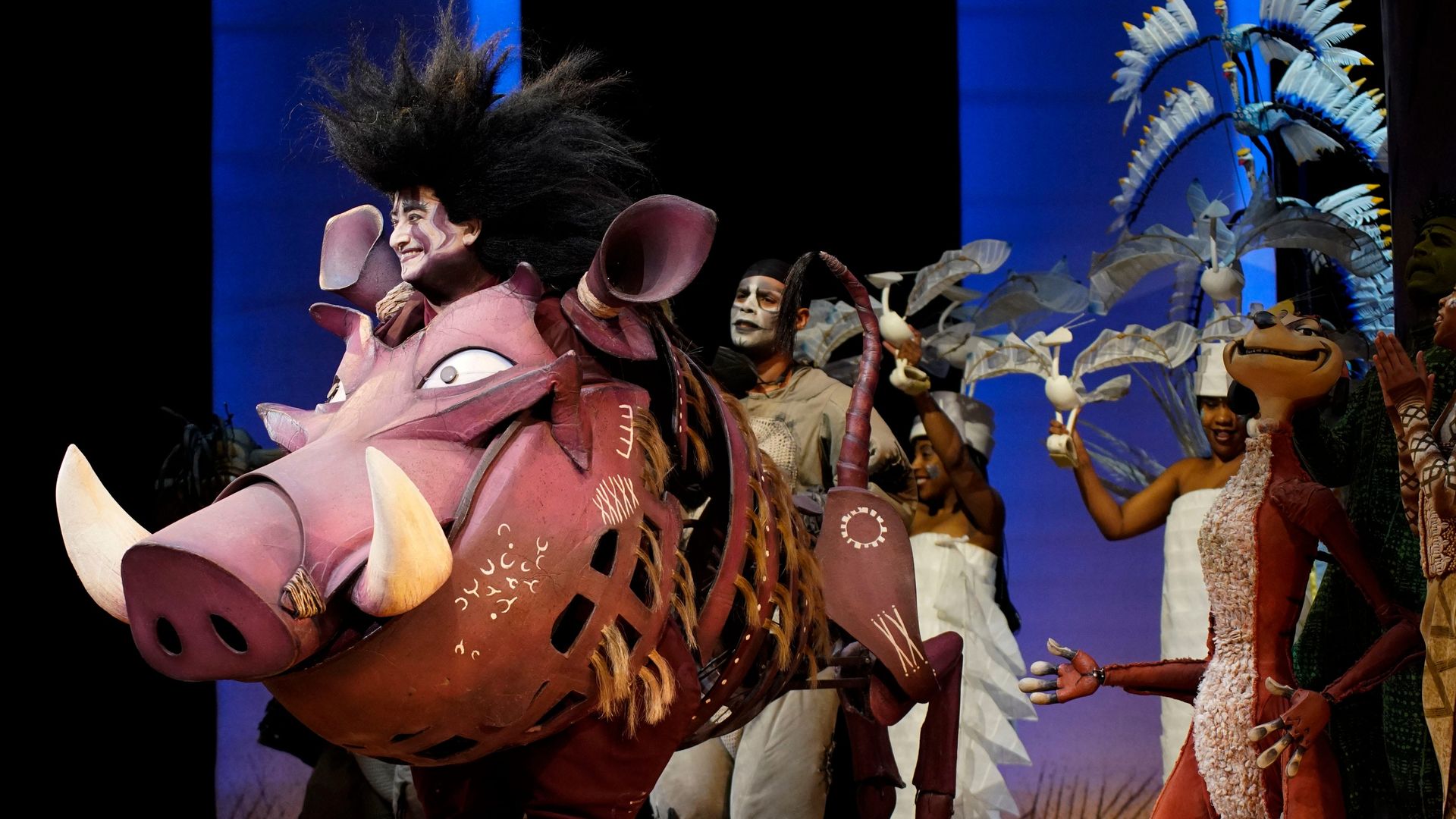 Cast members from "The Lion King" musical on stage.