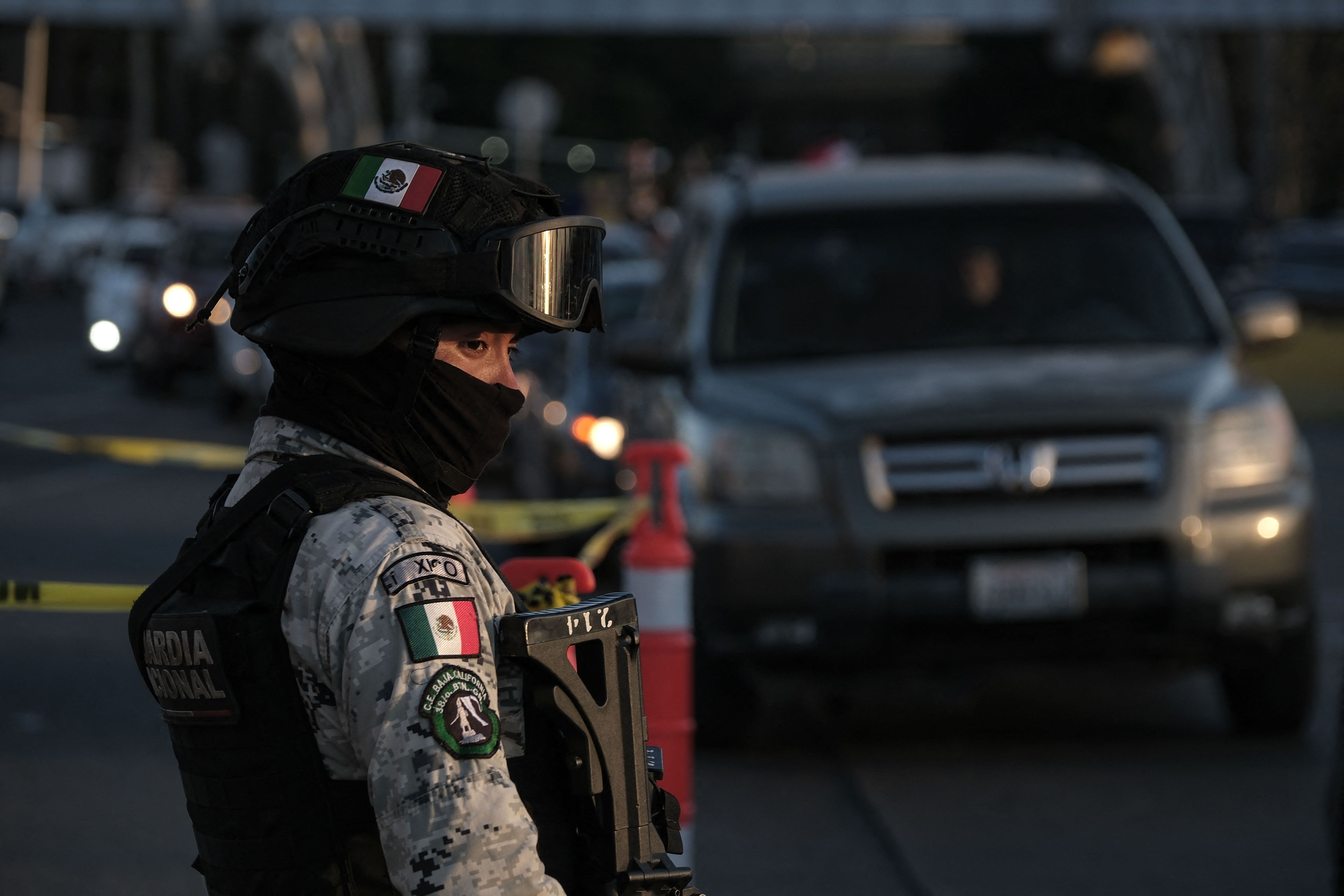 A Mexican National Guard officer checks vehicles before they cross into the United States at the San Ysidro crossing port on the US-Mexico border, seen from Tijuana, Baja California State, Mexico, on December 3, 2024. The filter is part of a pilot program to reinforce security on the Mexican side. (