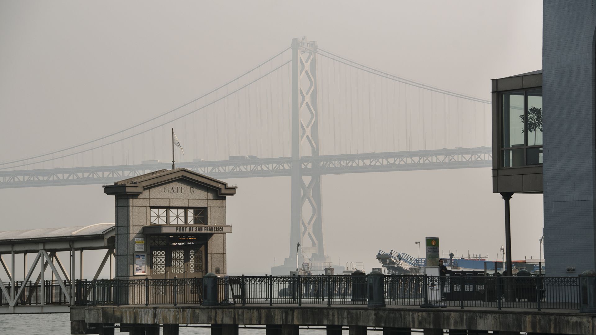 The California Bay Bridge is in the foreground but obscured by brown smoke during a wildfire