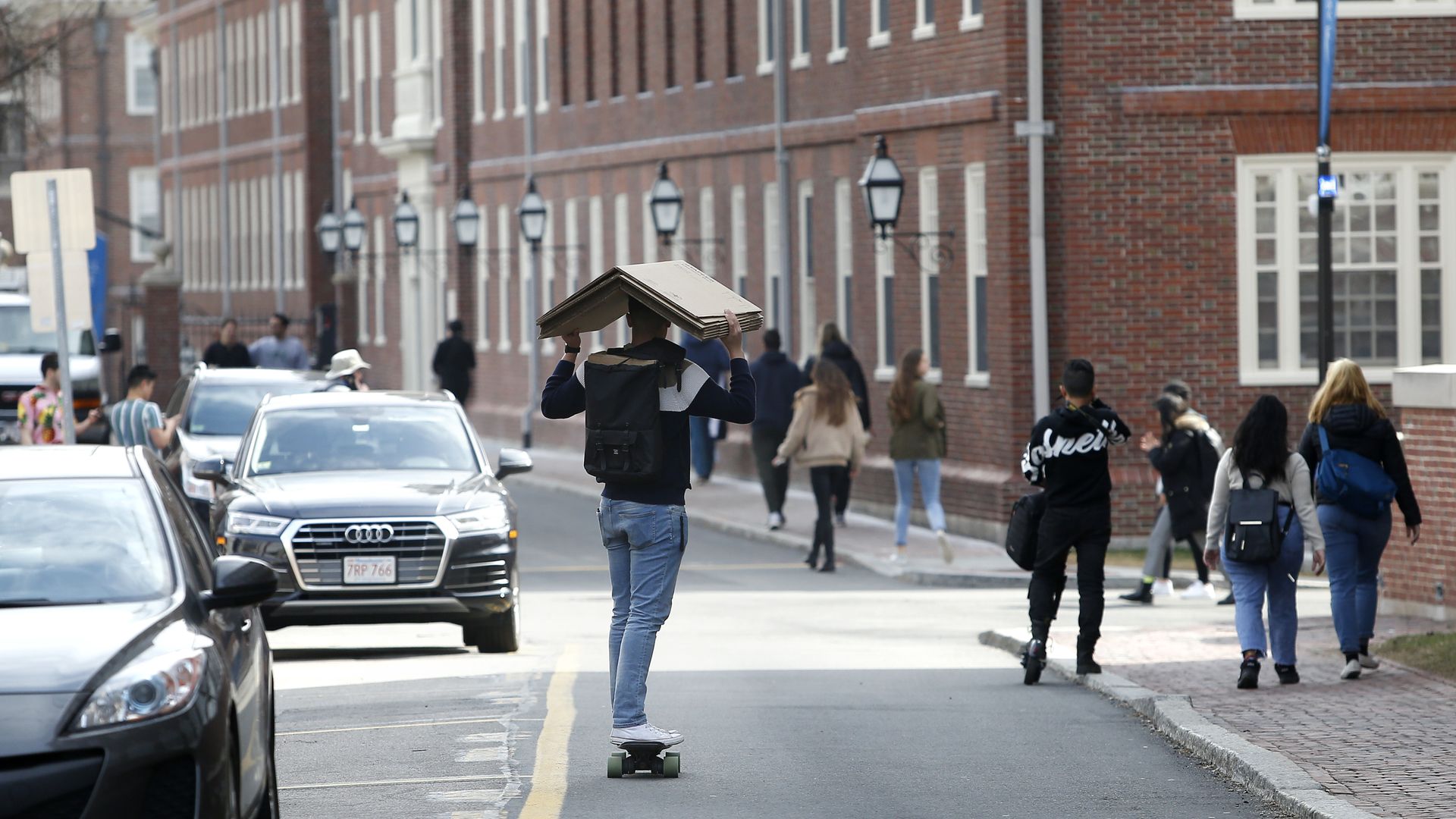 Harvard student carrying moving boxes