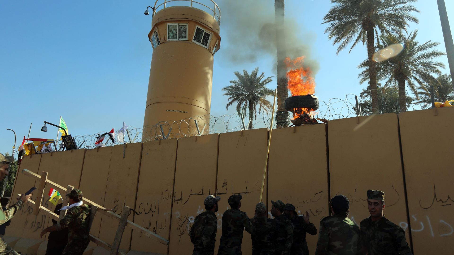 Protesters try to set fire to the outside fence of the U.S. embassy in Baghdad, Iraq on Dec. 31