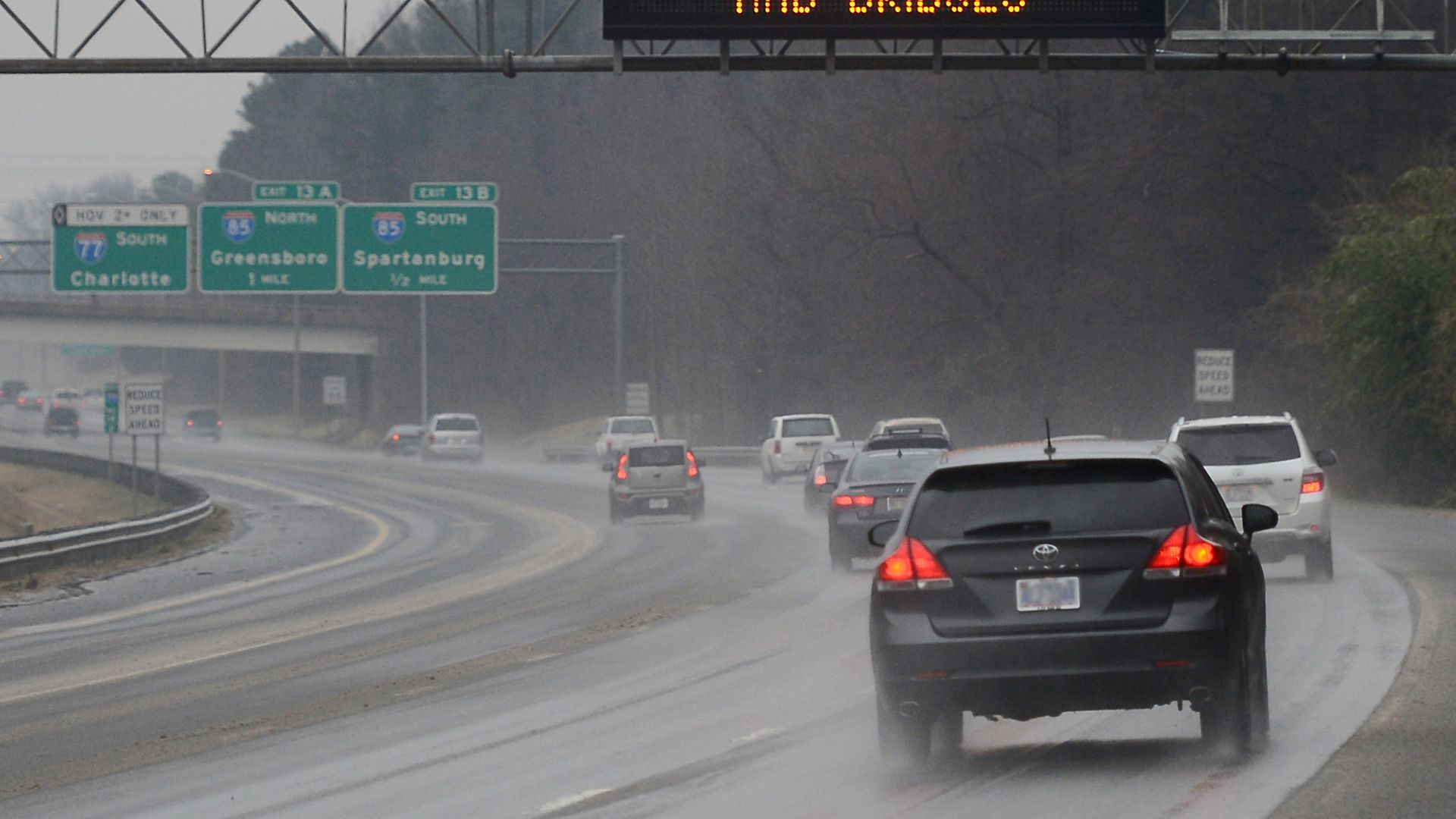Cars drive in the rain on i77