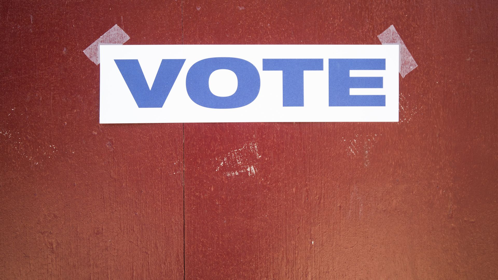 A "Vote" sign taped to a door.