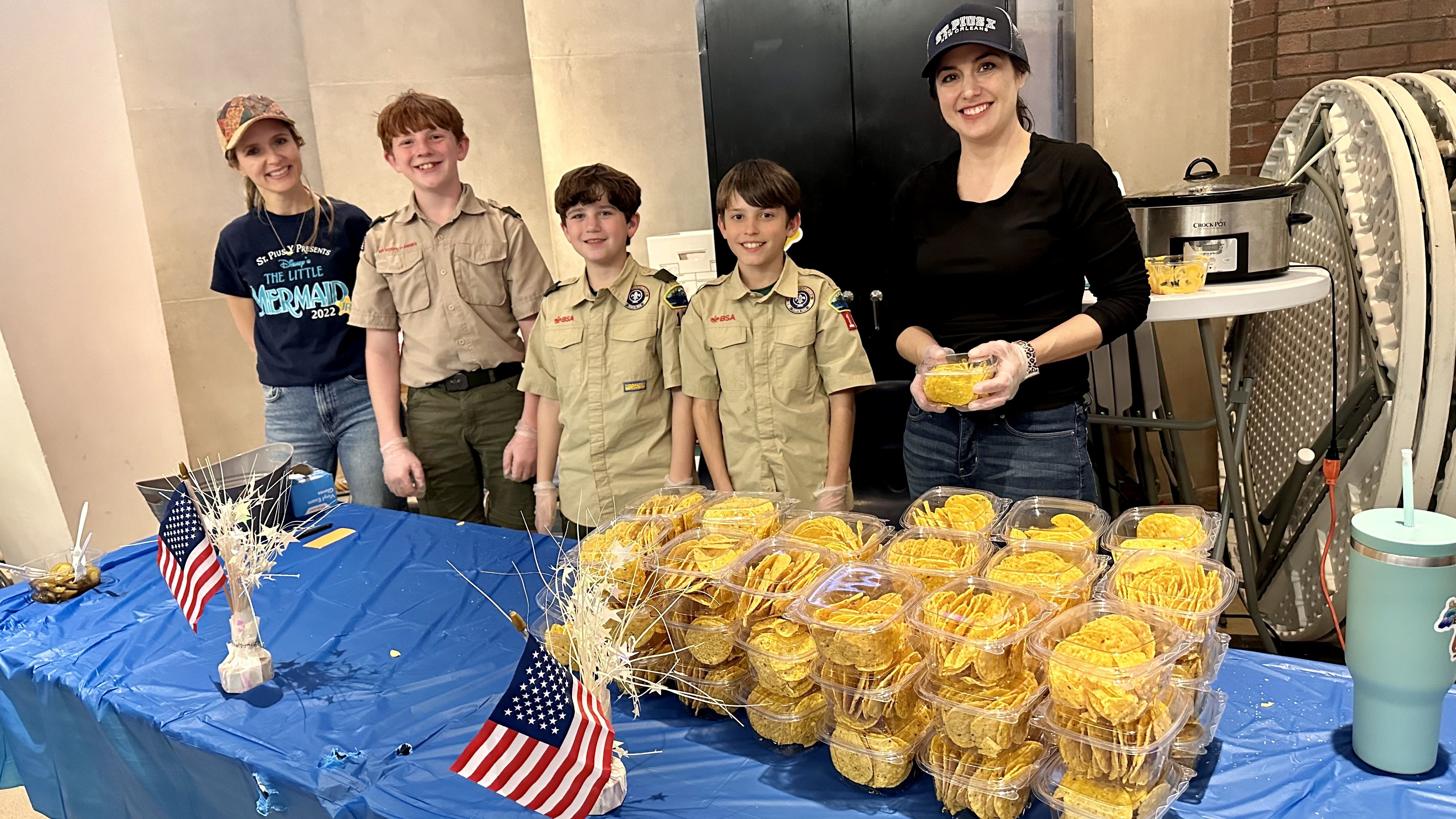 Photo shows Boy Scouts behind the nacho table.