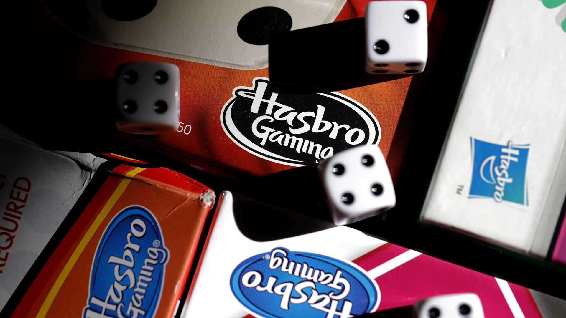 A Hasbro board arranged with dice. Photo Illustration by Justin Sullivan/Getty Images