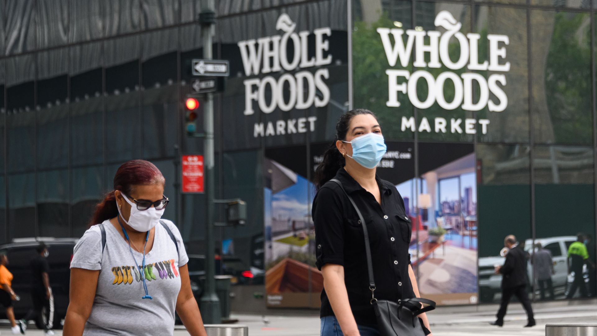 Image of masked people walking past a Whole Foods store