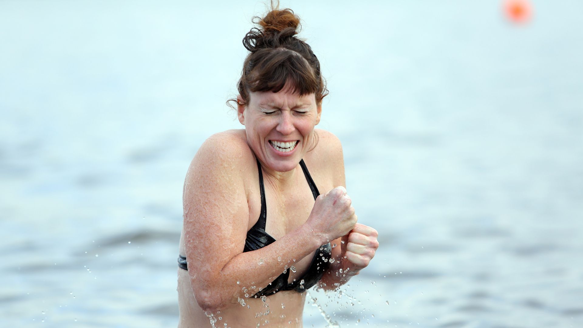 A woman shivers after jumping in the water during a polar bear plunge in Seattle. 