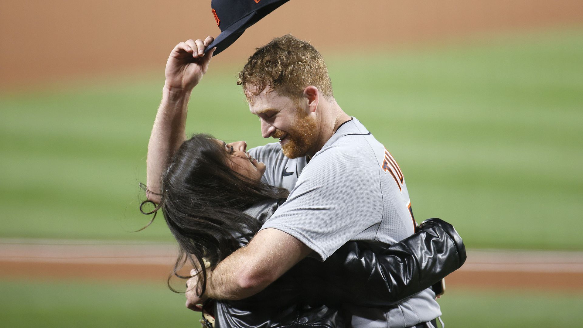 Two people hugging on a baseball field
